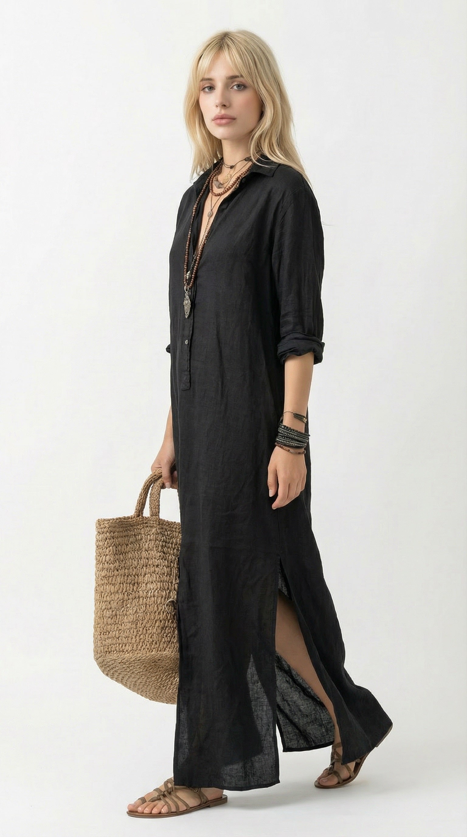 Woman wearing a black dress holding a woven bag against a neutral background