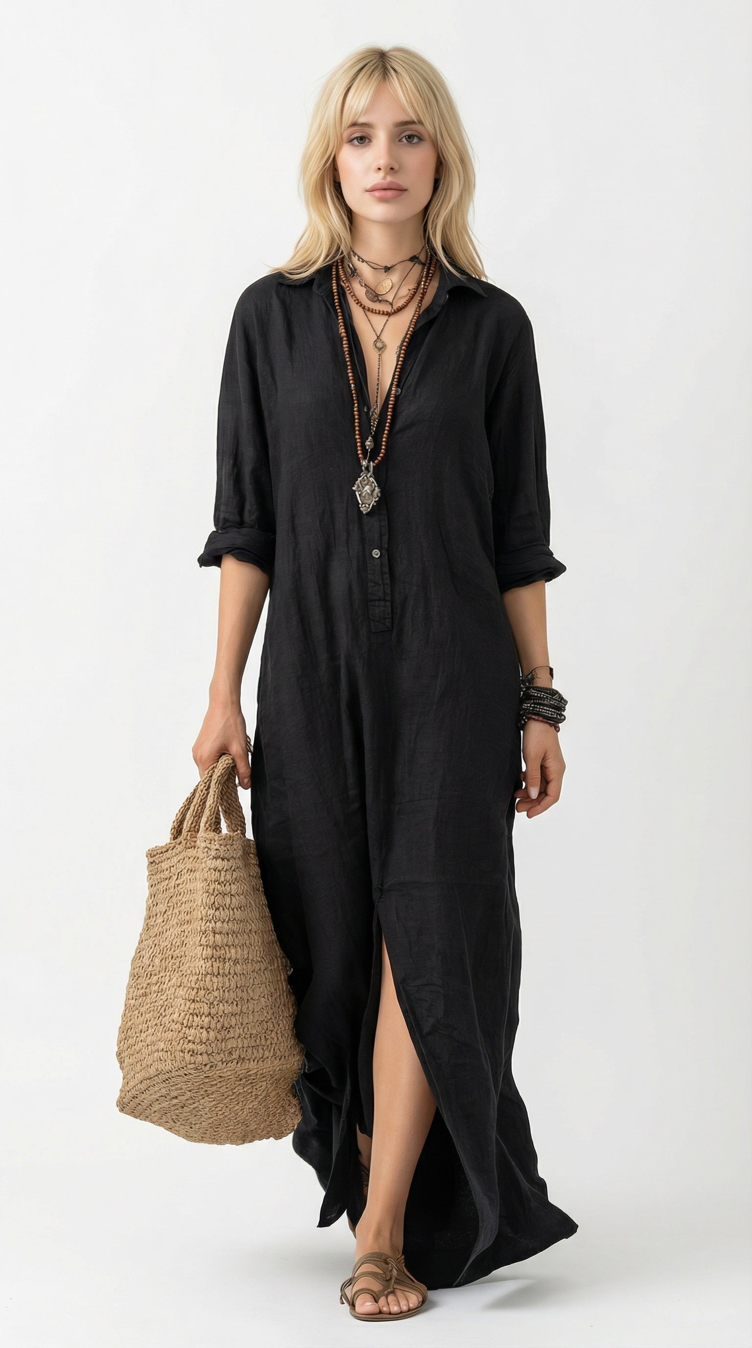 Woman wearing a black dress holding a woven bag against a neutral background