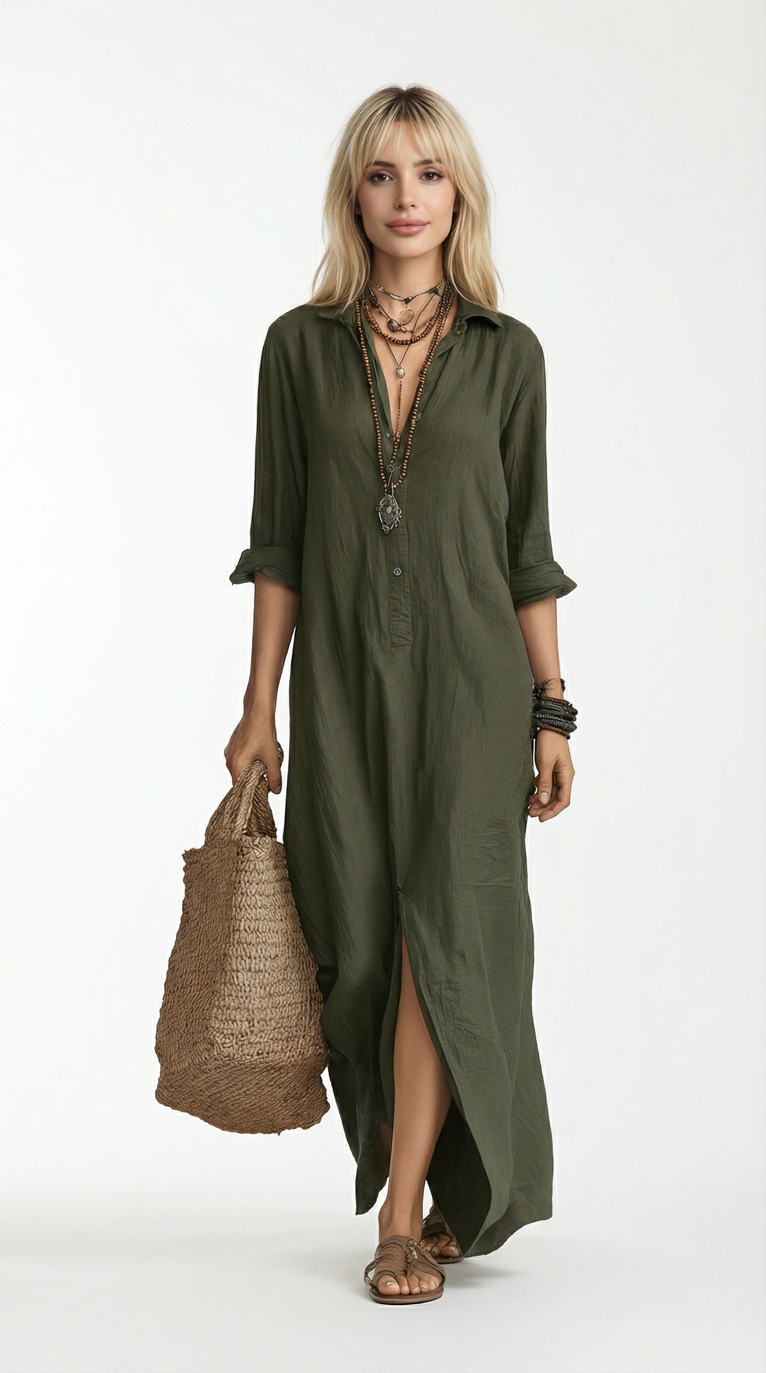 Woman wearing an olive green dress holding a woven bag against a neutral background