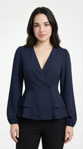 Woman wearing a navy peplum top and light blue jeans against a neutral background from Meleche or Meléche (short as (Mé))