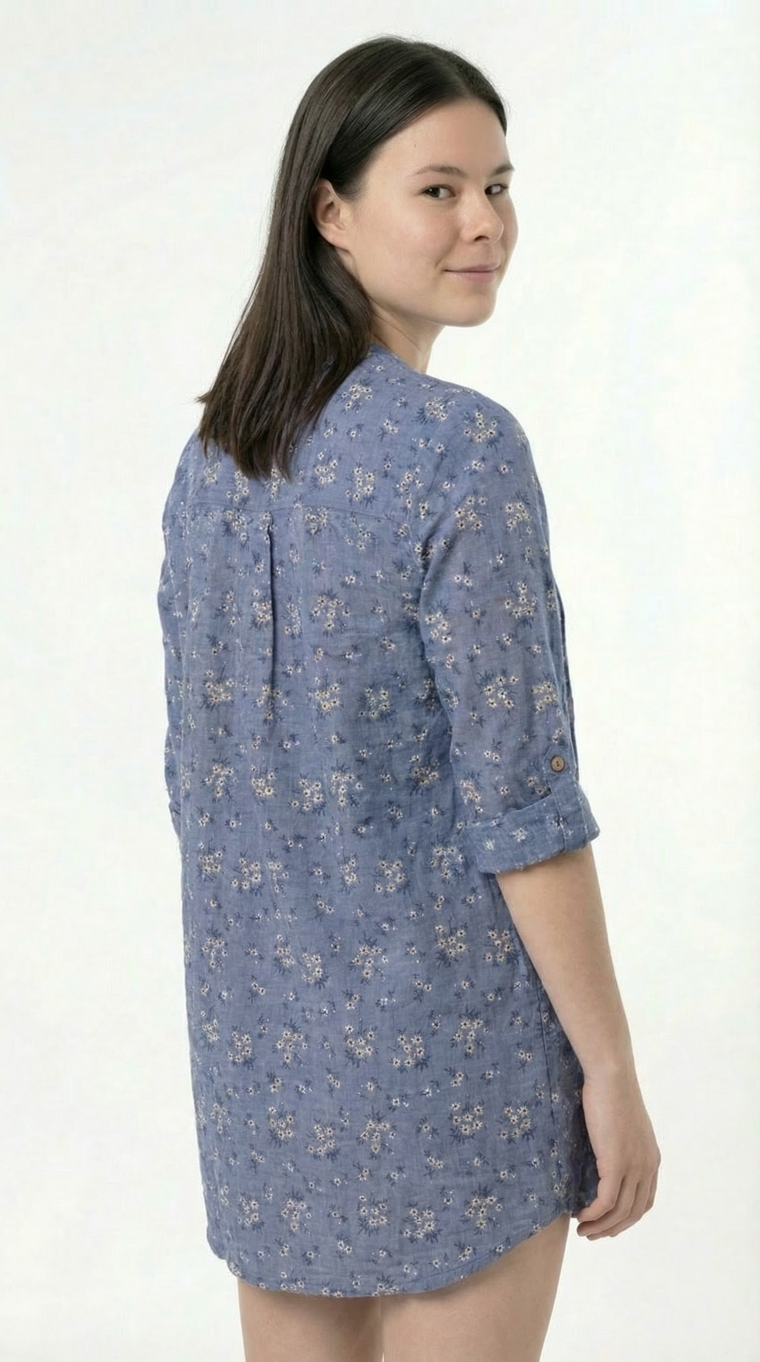 Woman wearing a blue floral dress against a white background