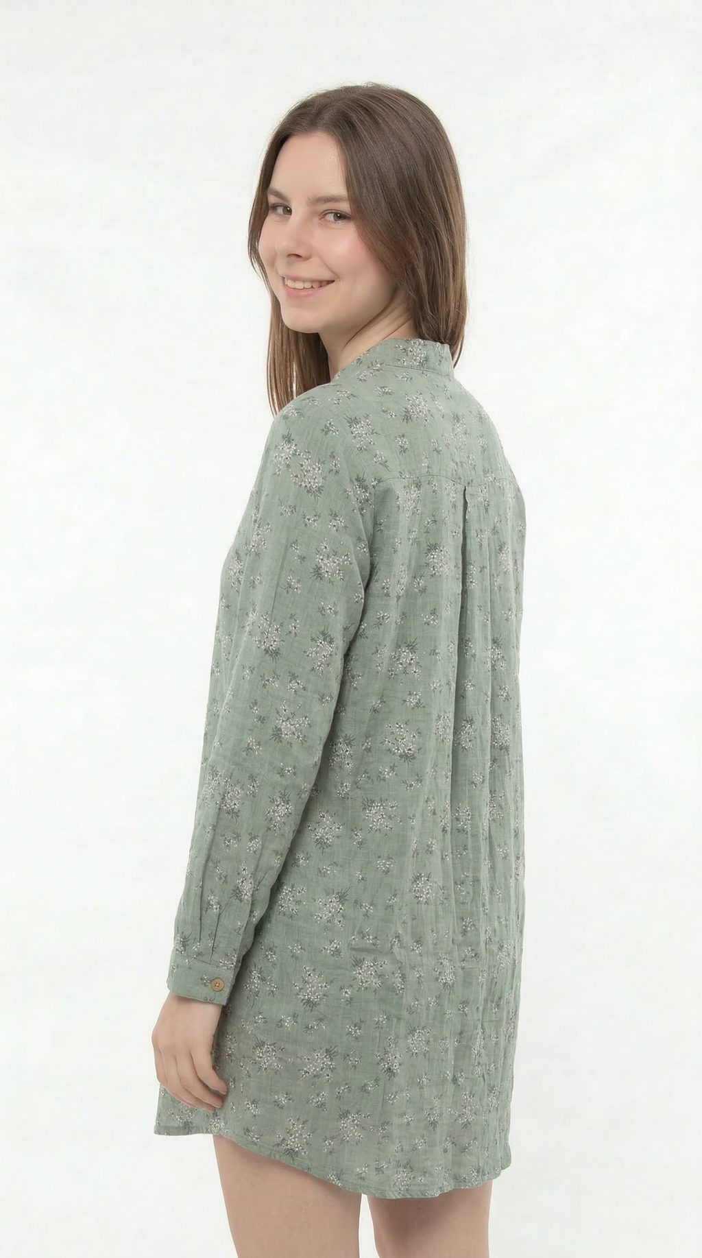 Woman wearing a green patterned shirt dress on a white background
