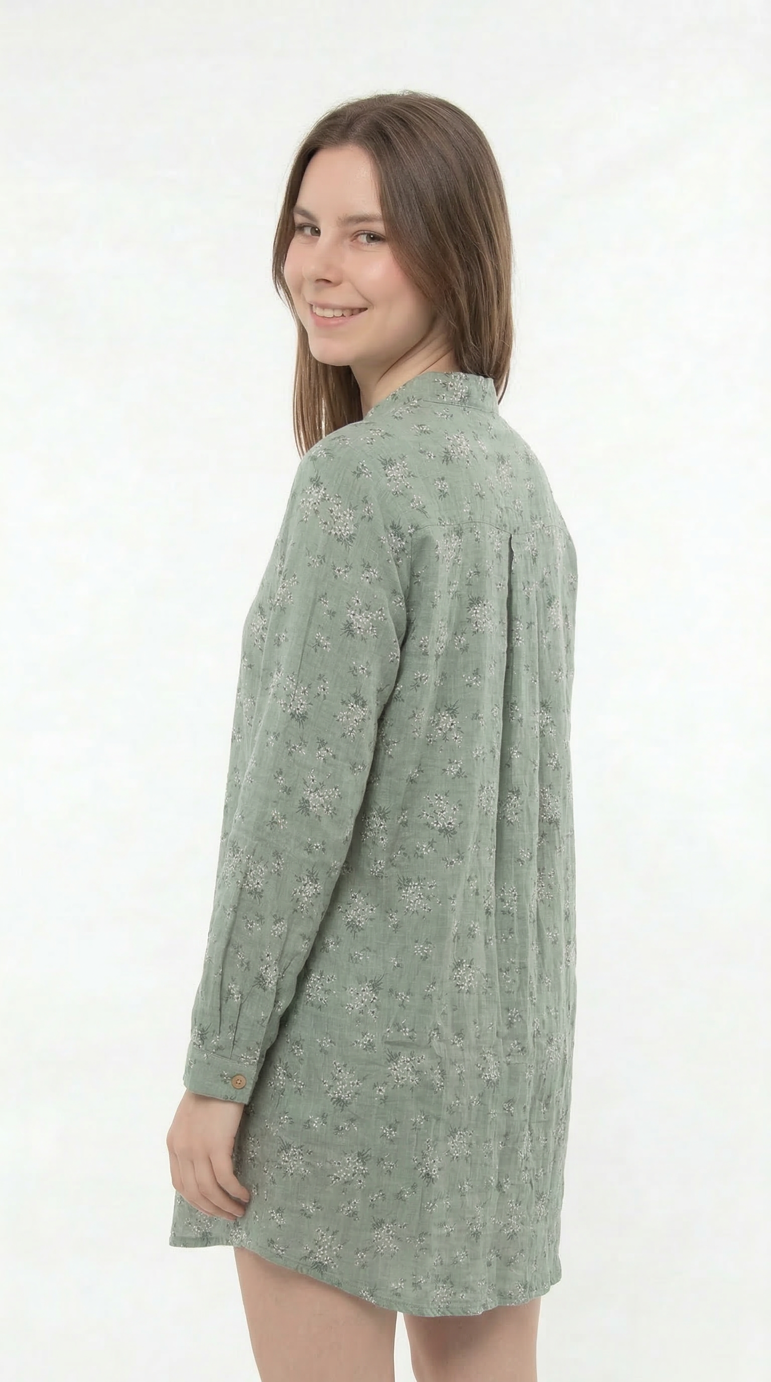 Woman wearing a green patterned shirt dress on a white background