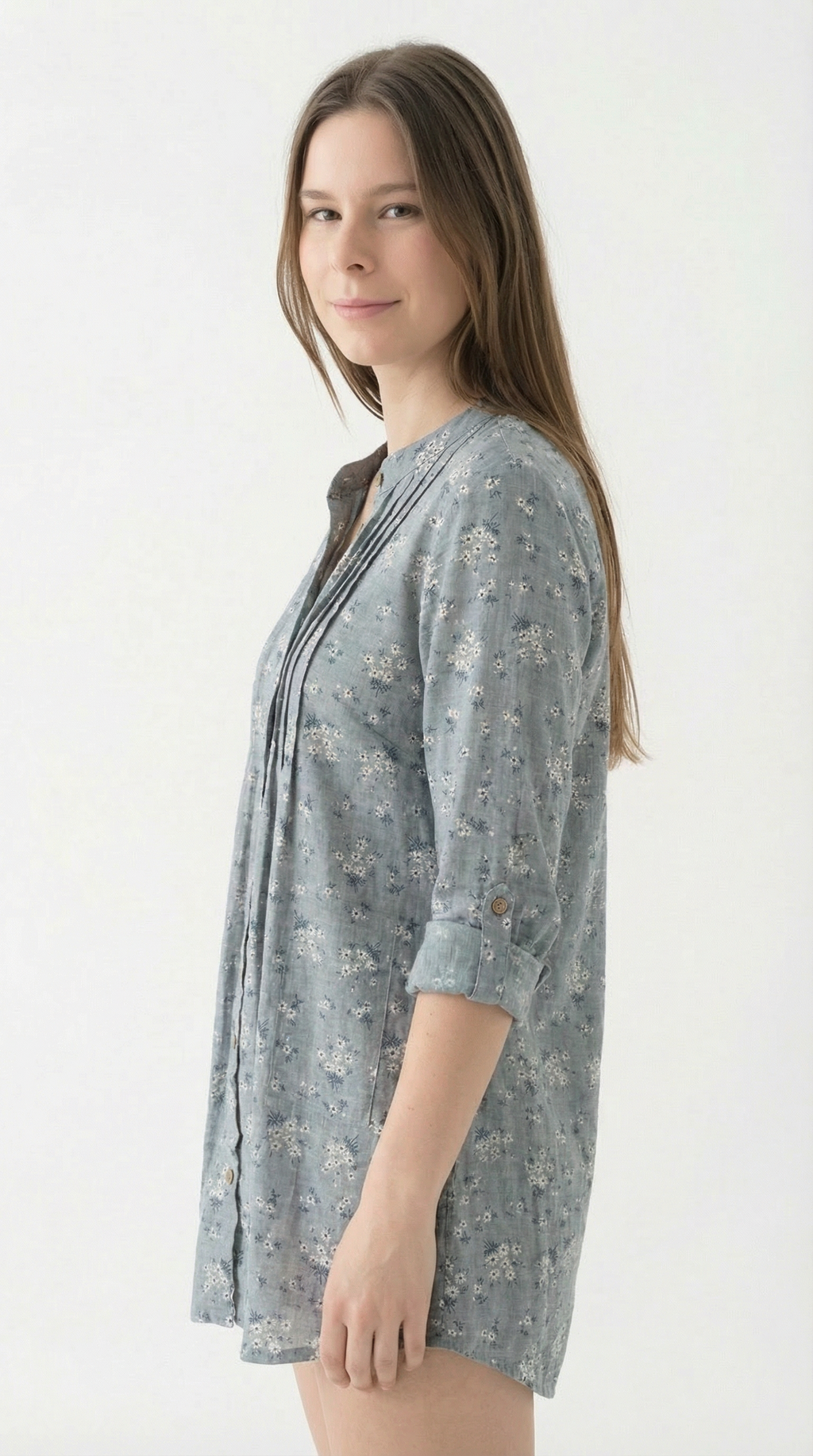 Woman wearing a light blue floral patterned shirt on a white background