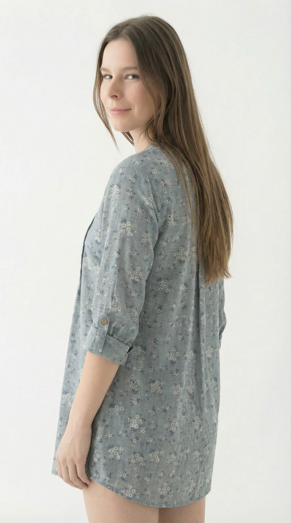 Woman wearing a gray floral dress against a white background