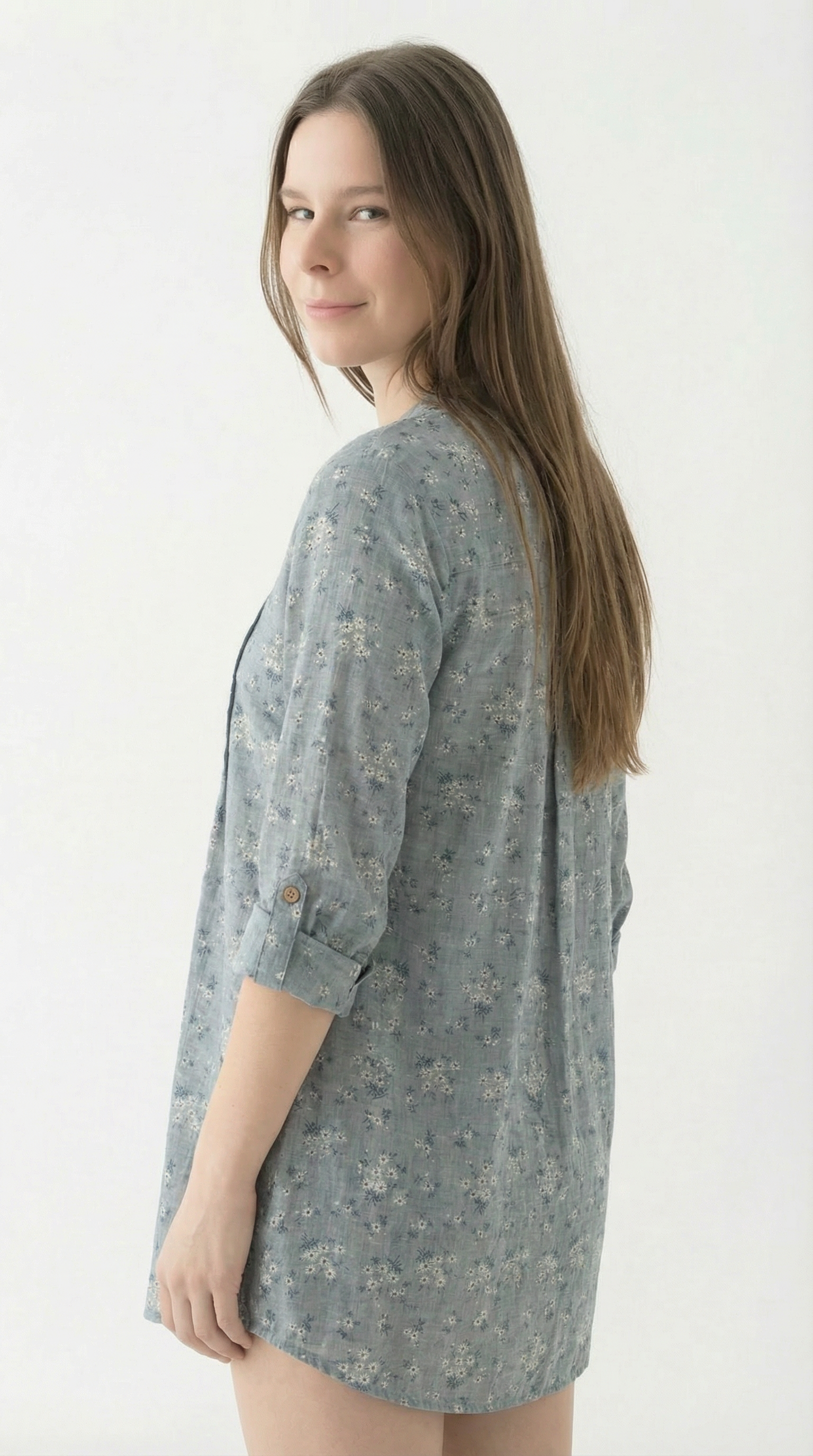 Woman wearing a gray floral dress against a white background