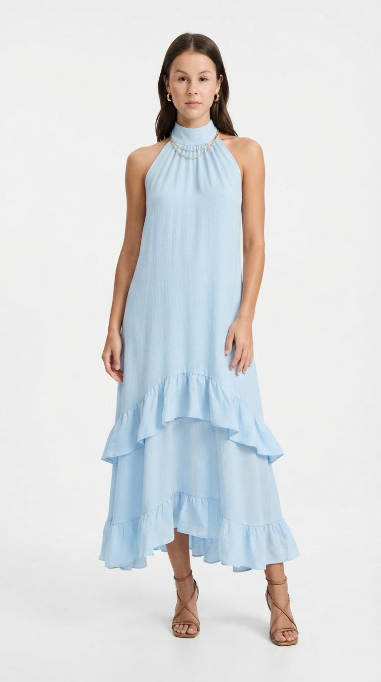 A woman modeling a light blue halter-neck midi dress with a high-low ruffled hem and a pearl collar, paired with brown strappy high-heeled sandals against a white studio background, from Meleche Fashion USA or Meléche (short as (Mé))