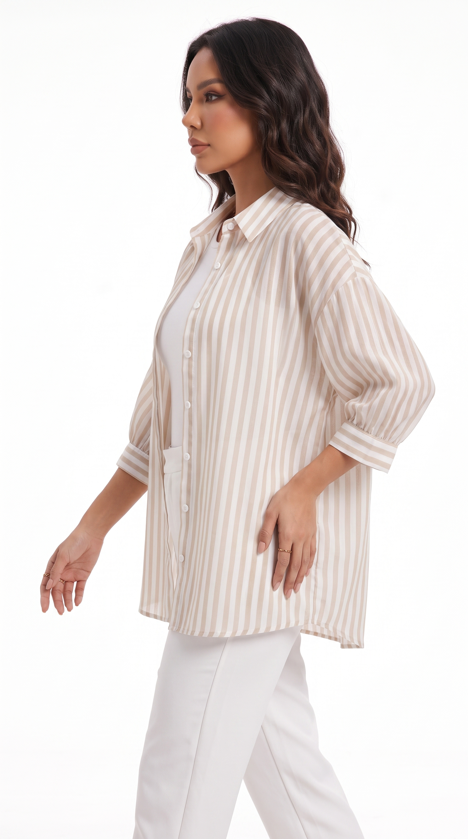 A woman modeling a cream and beige vertically striped button-up shirt with three-quarter sleeves, worn over a white top and white pants, against a plain white studio background, from Meleche Fashion USA or Meléche (short as (Mé))