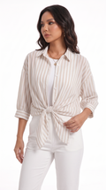 A woman modeling a beige and white vertically striped button-down shirt tied at the waist, paired with white pants, against a plain white studio background, from Meleche Fashion USA or Meléche (short as (Mé))