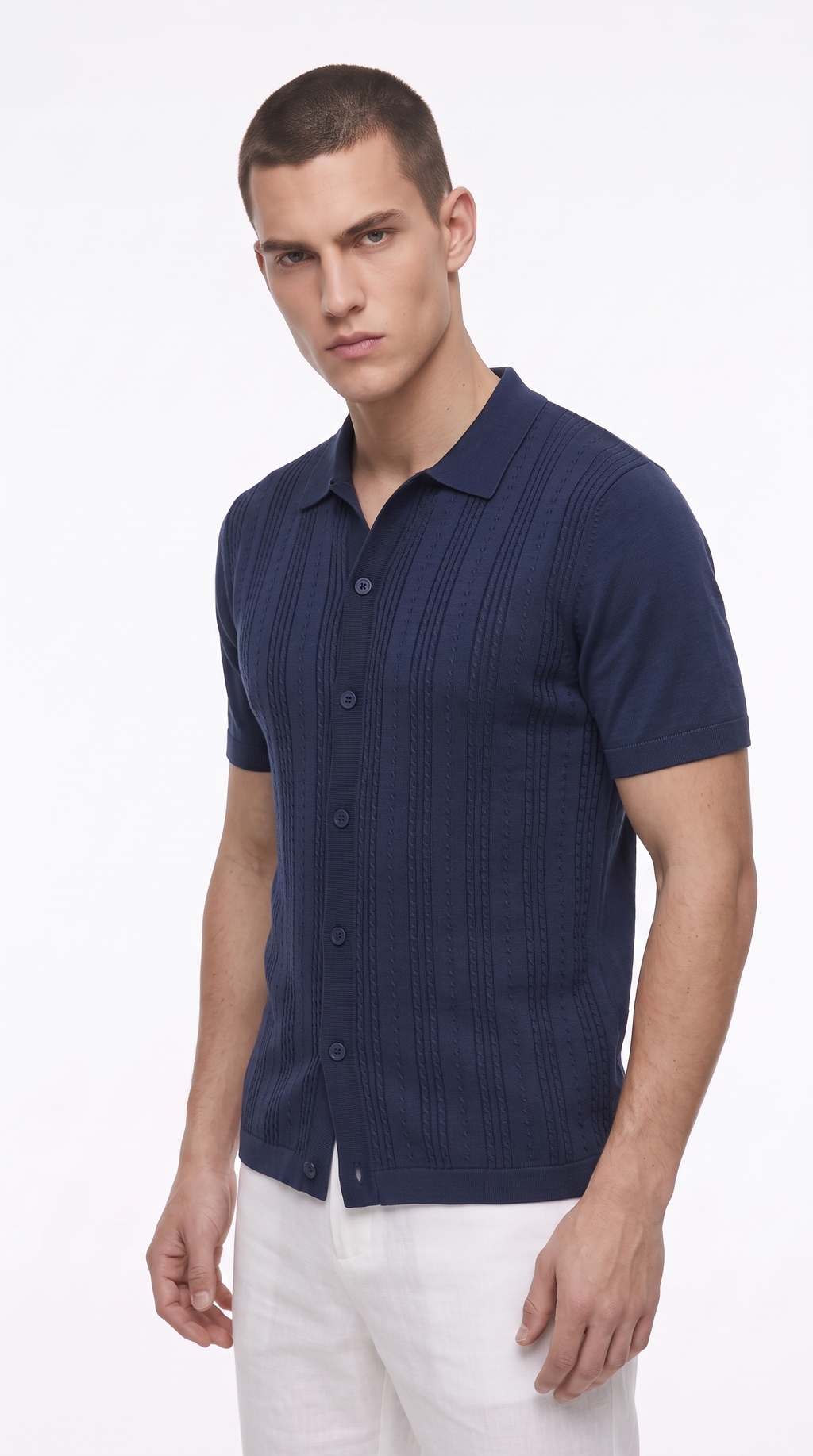 A man wearing a navy blue short-sleeve knit polo shirt with a button-down front and white trousers, photographed against a clean white studio background, from Meleche Fashion USA or Meléche (short as (Mé))