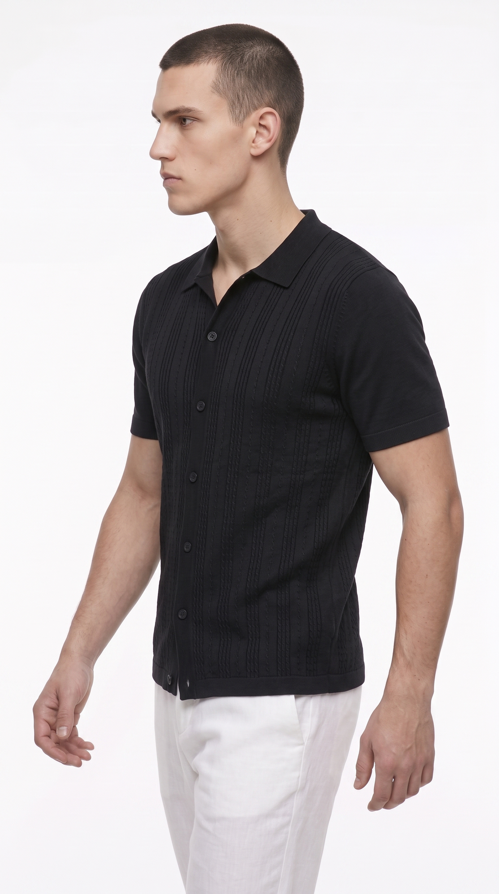 A man wearing a black short-sleeve button-up shirt with a subtle vertical ribbed texture and white trousers, photographed against a plain white studio background, from Meleche Fashion USA or Meléche (short as (Mé))