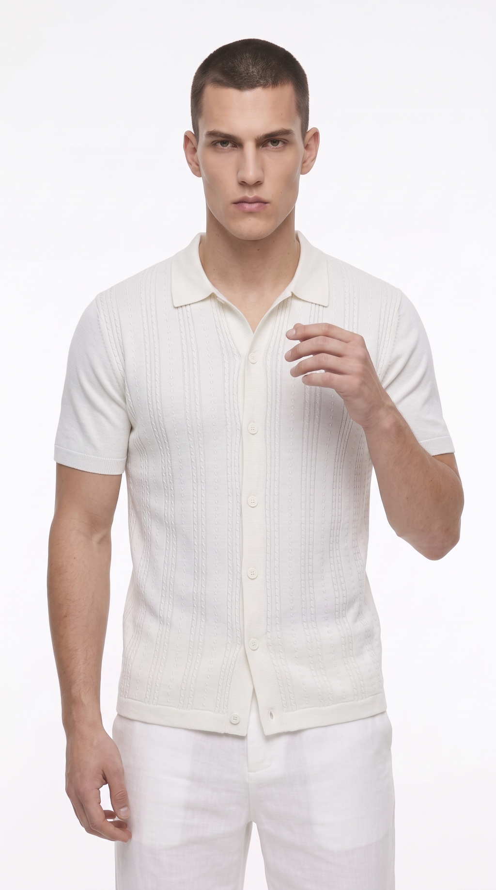 A male model wearing a short-sleeve knit polo shirt in off-white with a textured vertical stripe pattern, paired with white trousers, against a plain white studio background, from Meleche Fashion USA or Meléche (short as (Mé))