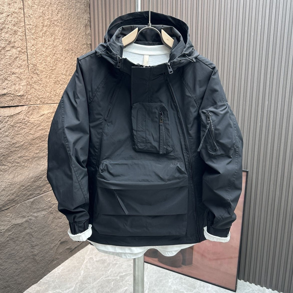 Black jacket with white cuffs on a mannequin against a textured wall.