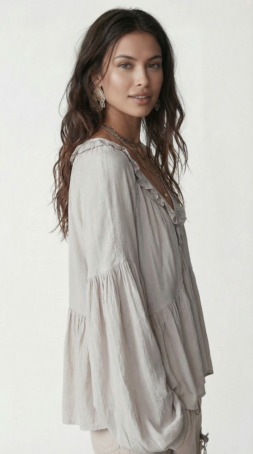 Woman wearing a light gray blouse with ruffled sleeves on a white background from Meleche Fashion USA or Meléche (short as (Mé))