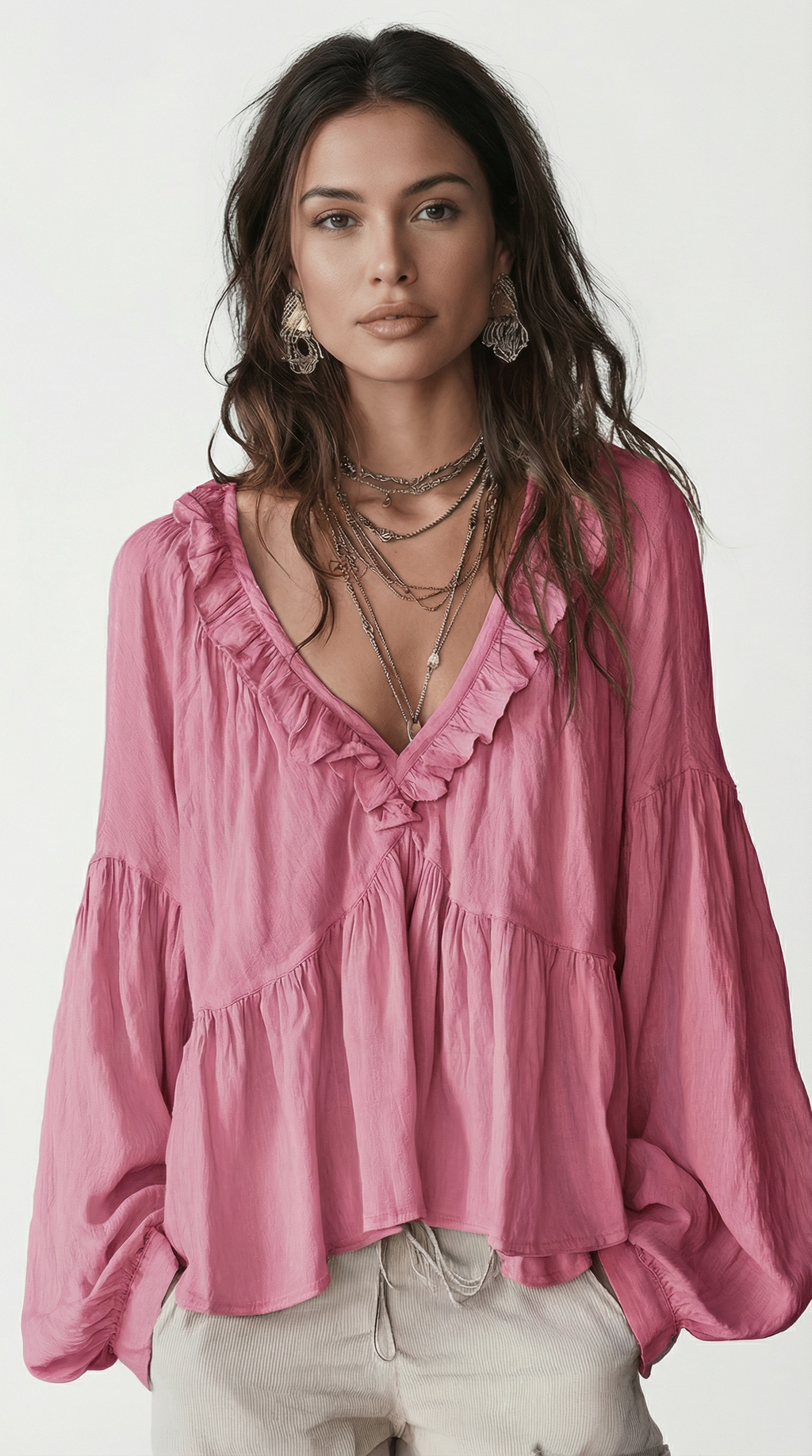 Woman wearing a pink blouse with ruffled details on a white background from Meleche Fashion USA or Meléche (short as (Mé))