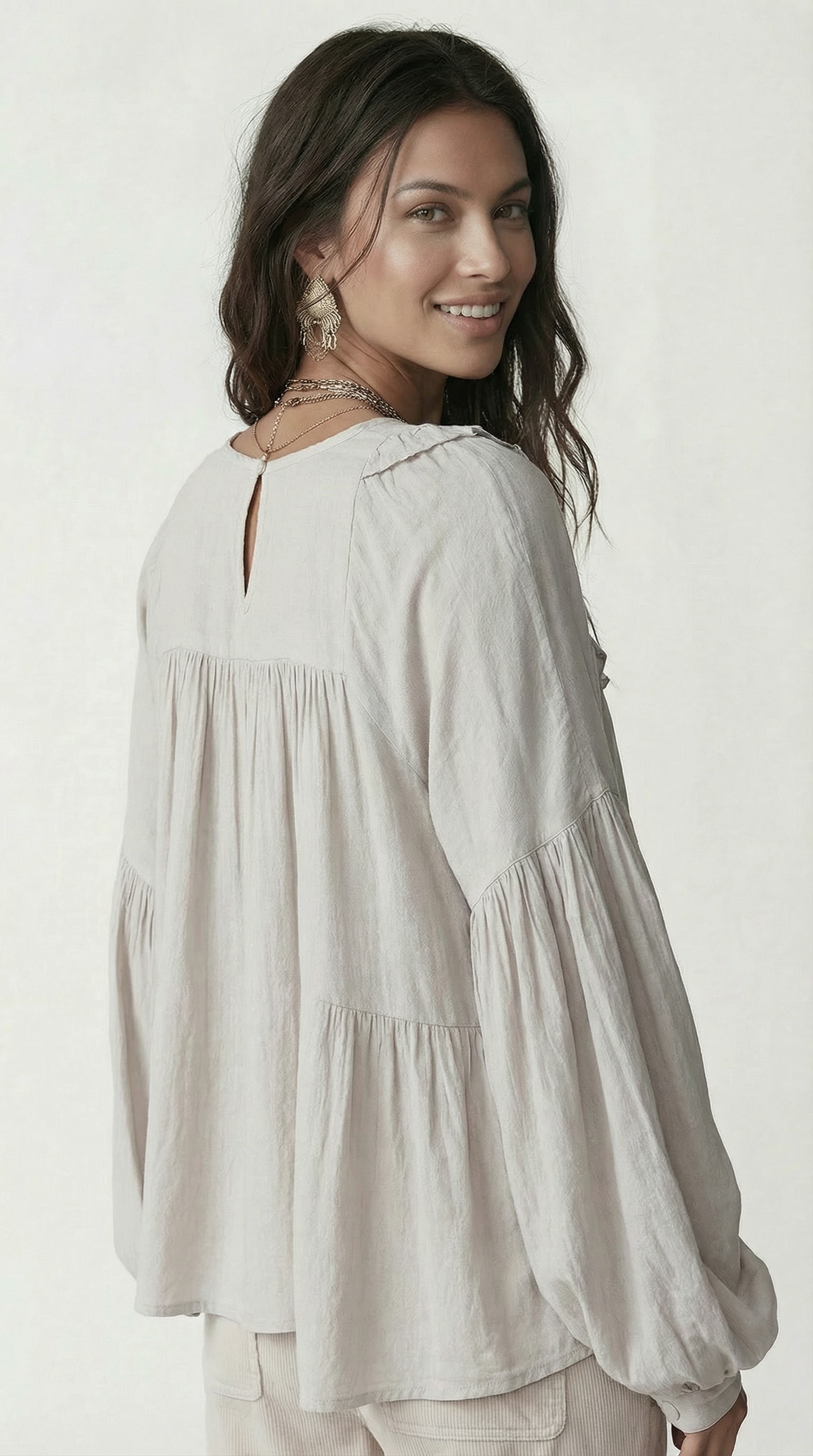 Woman wearing a light gray blouse against a white background