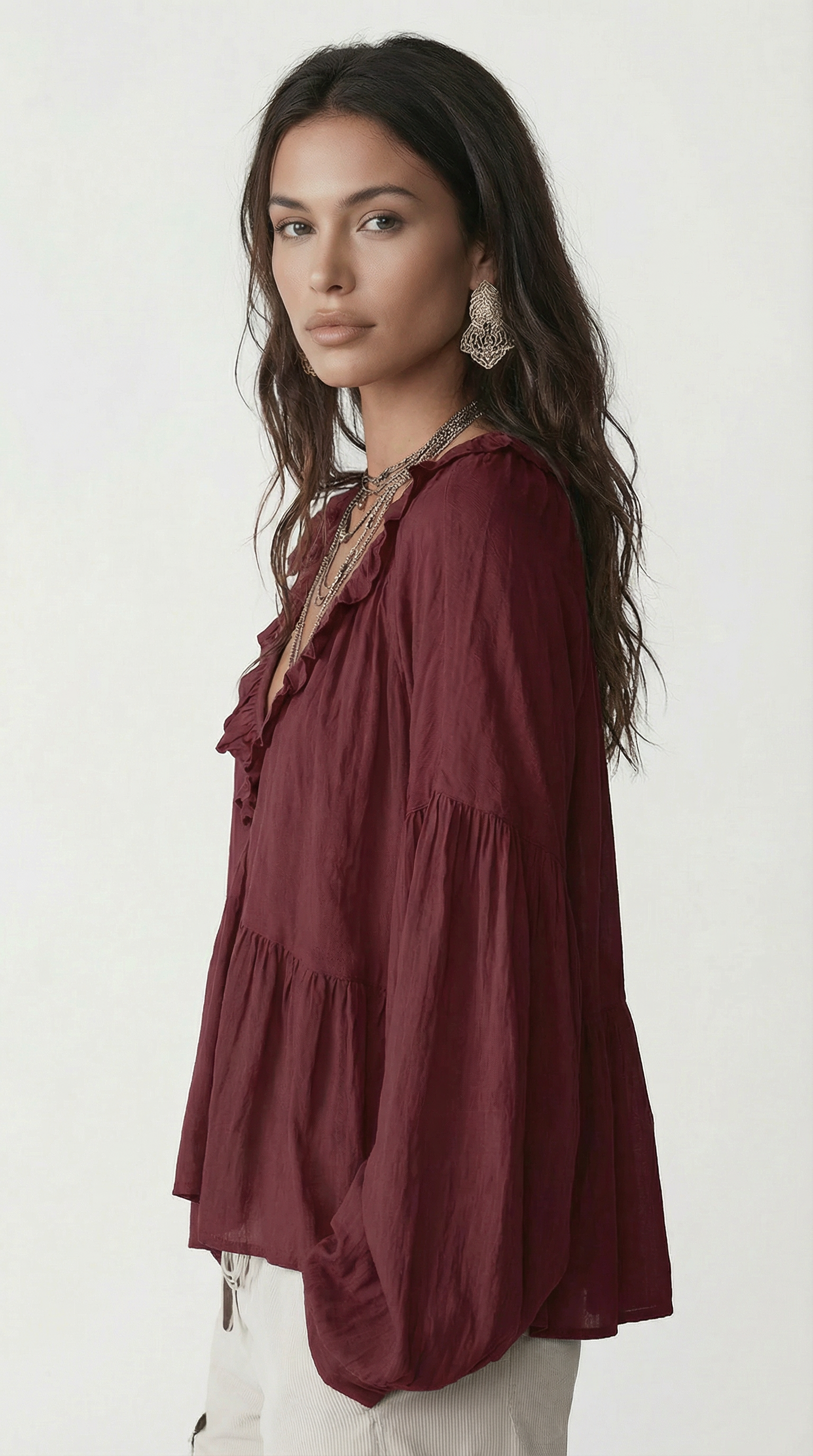 Woman wearing a burgundy blouse with ruffled details on a white background from Meleche Fashion USA or Meléche (short as (Mé))