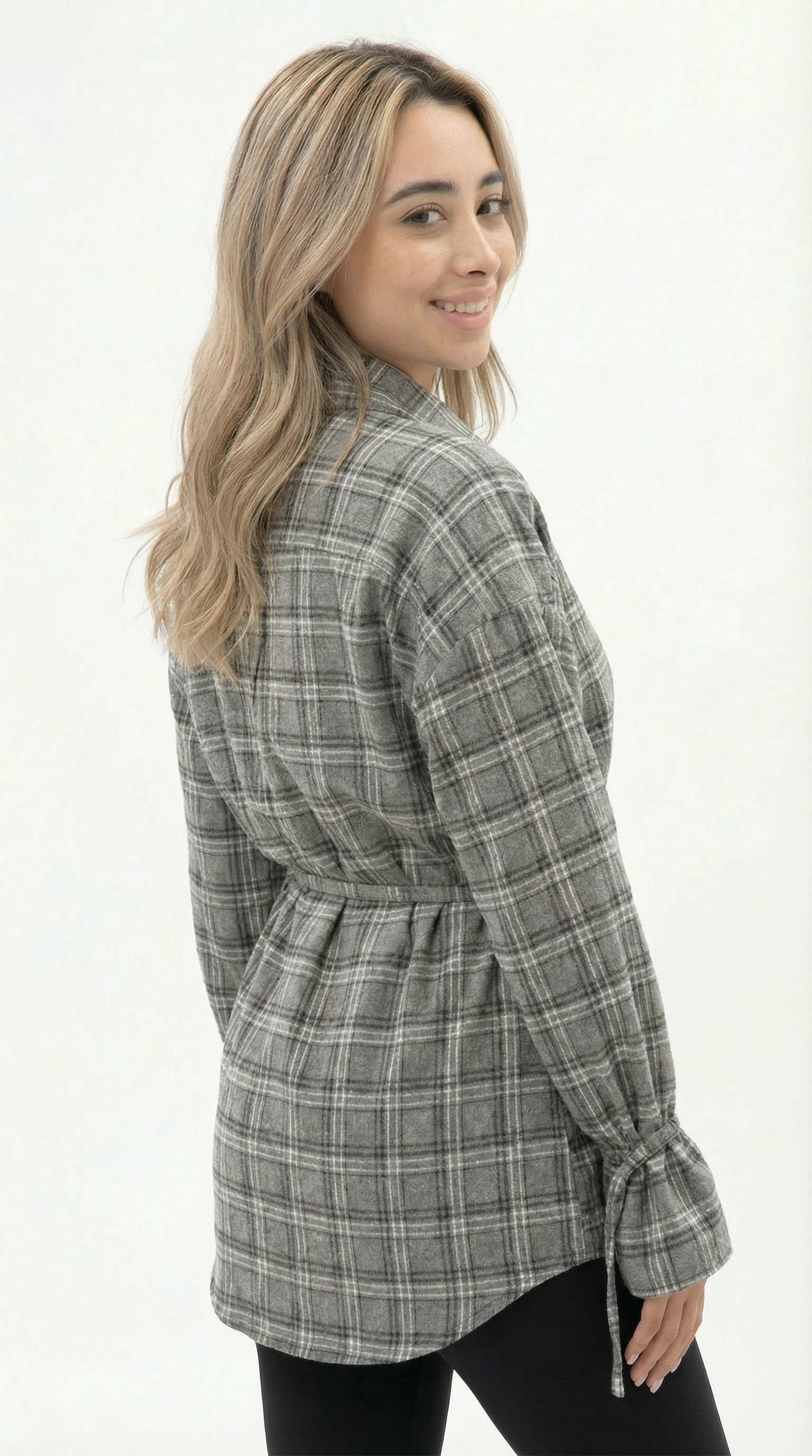 Woman wearing a plaid shirt with a belt on a white background