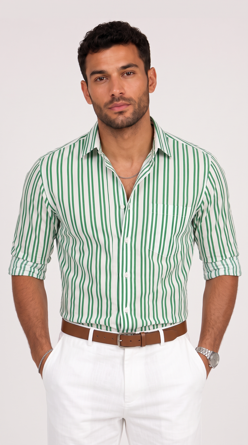 A man wearing a green and white vertically striped button-down shirt with white trousers and a brown belt, standing against a light gray studio background, from Meleche Fashion USA or Meléche (short as (Mé))