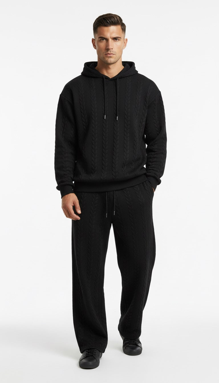 Man wearing a black hoodie and pants on a white background