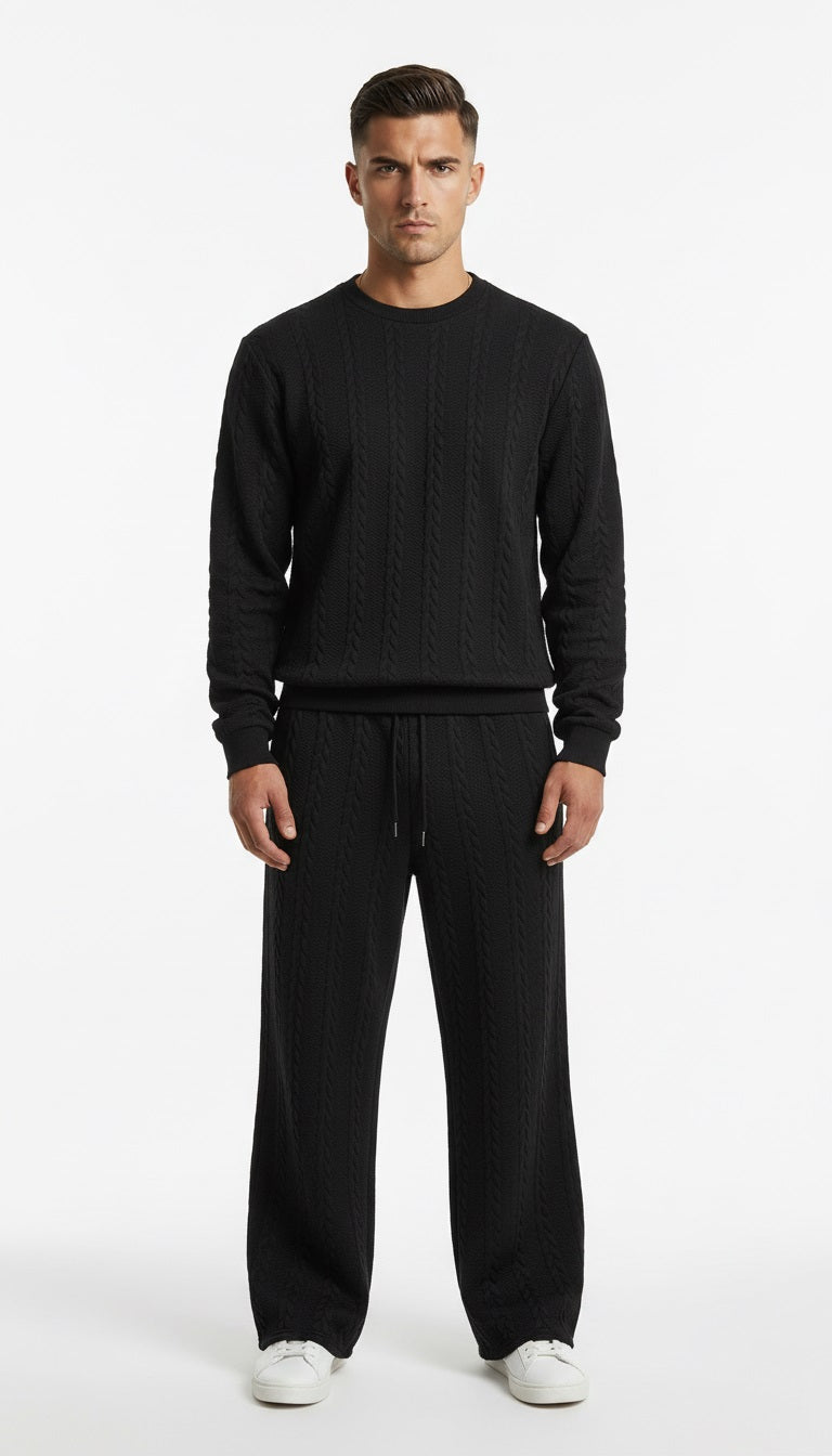 Man wearing a black sweater and pants on a white background
