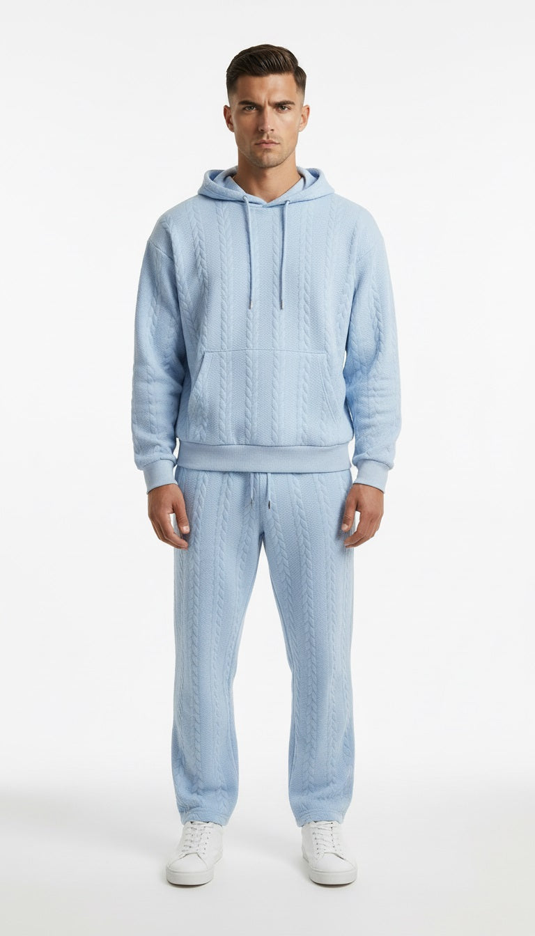 Man wearing a light blue textured hoodie and pants set on a white background