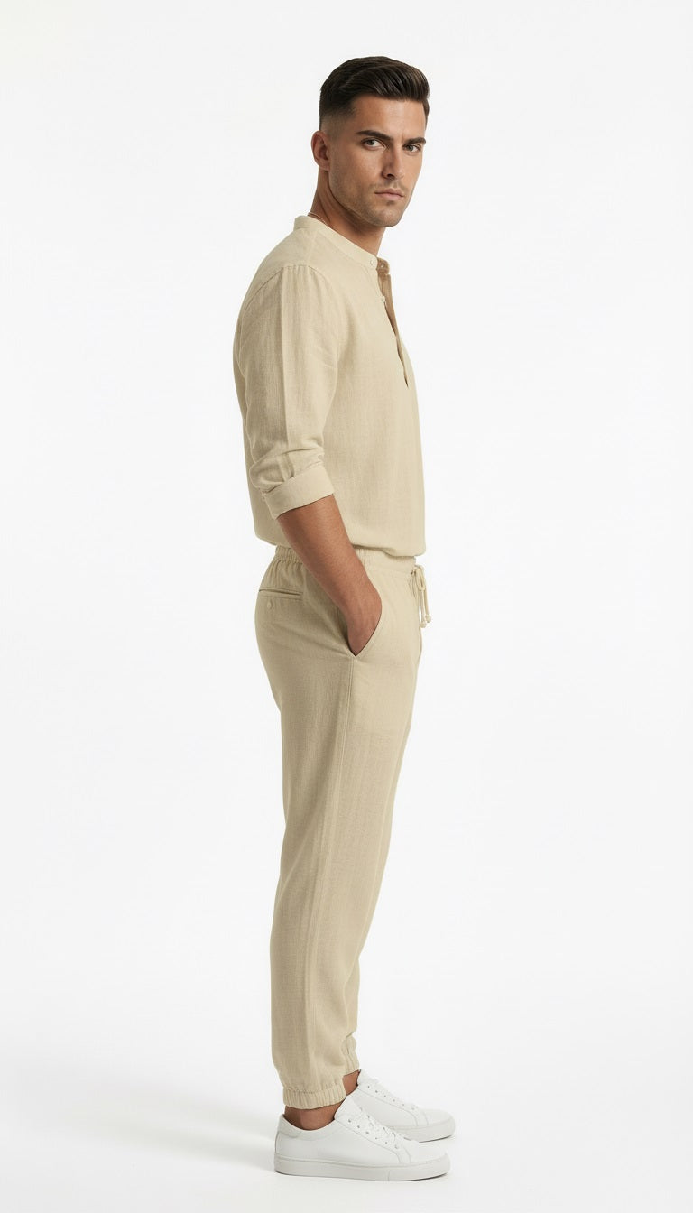 Man wearing a beige shirt and pants with white shoes on a white background