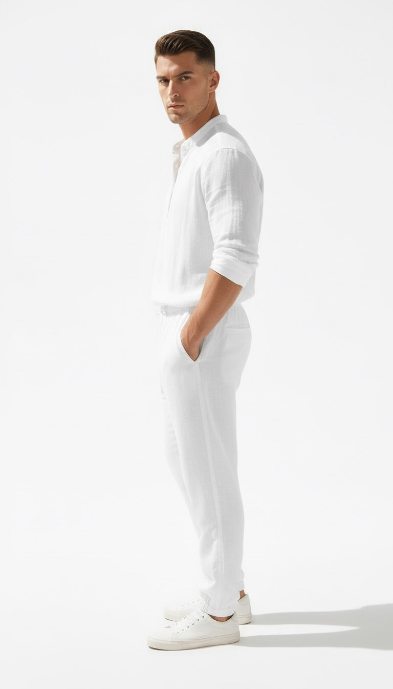 Man wearing a white outfit standing against a white background