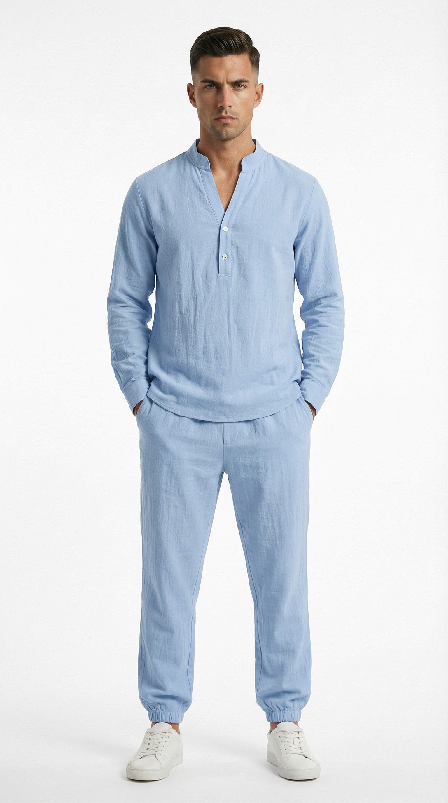 Man in light blue outfit standing on a balcony with ocean view and yachts.