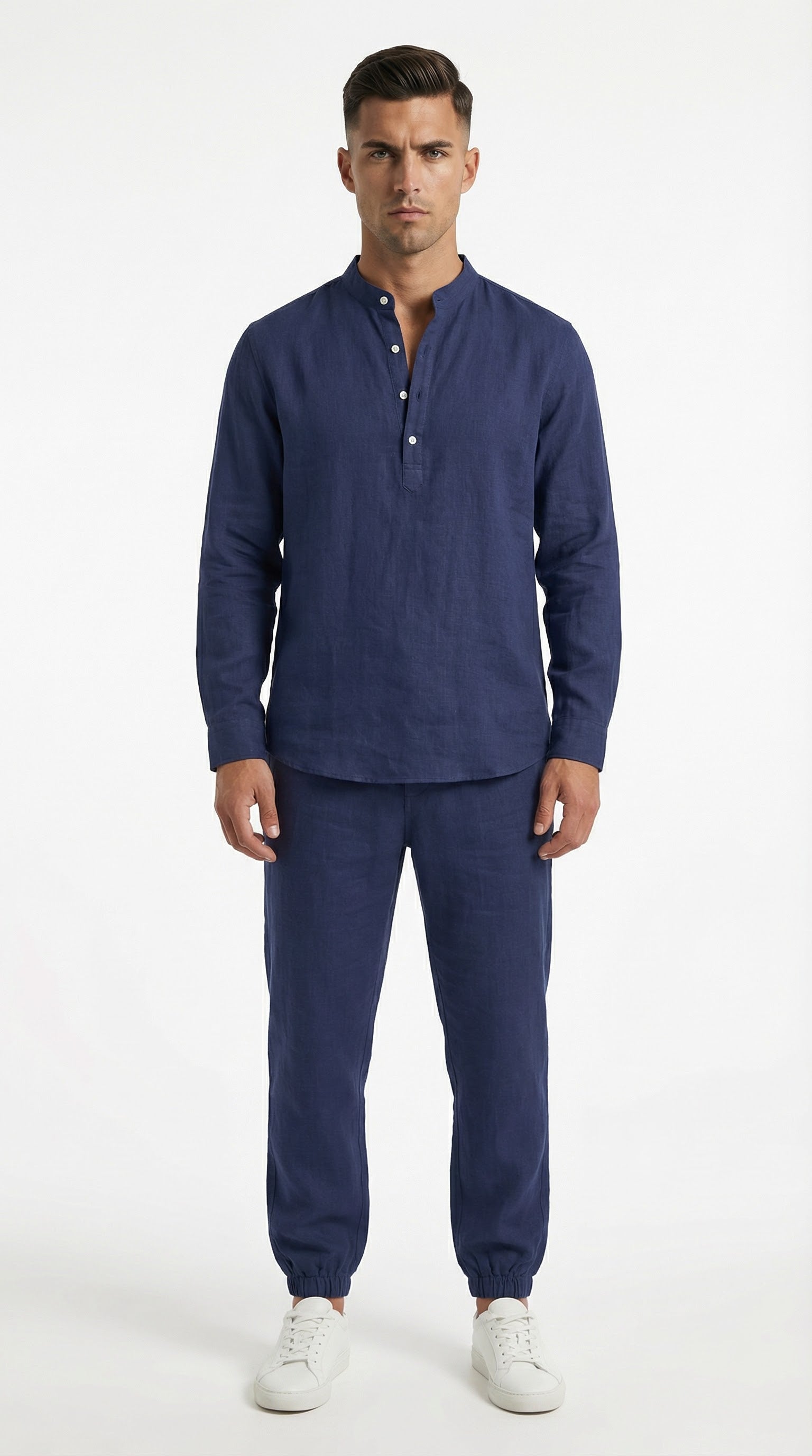 Man in navy blue outfit standing on a balcony with ocean view and yachts.