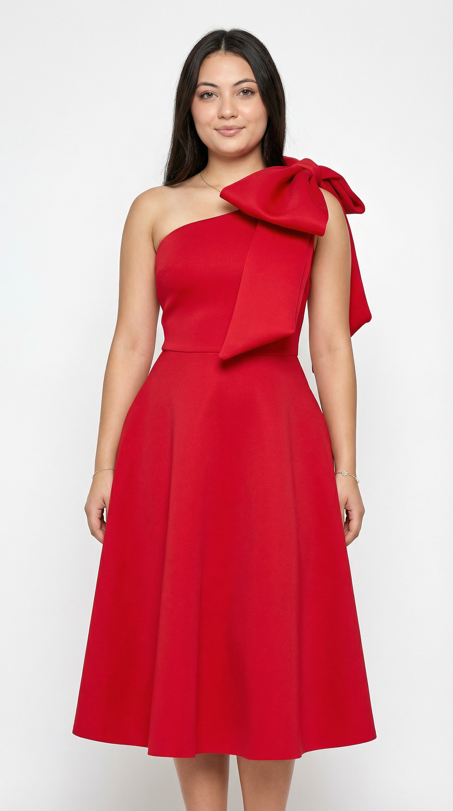 Woman wearing a red one-shoulder dress with a large bow on a white background