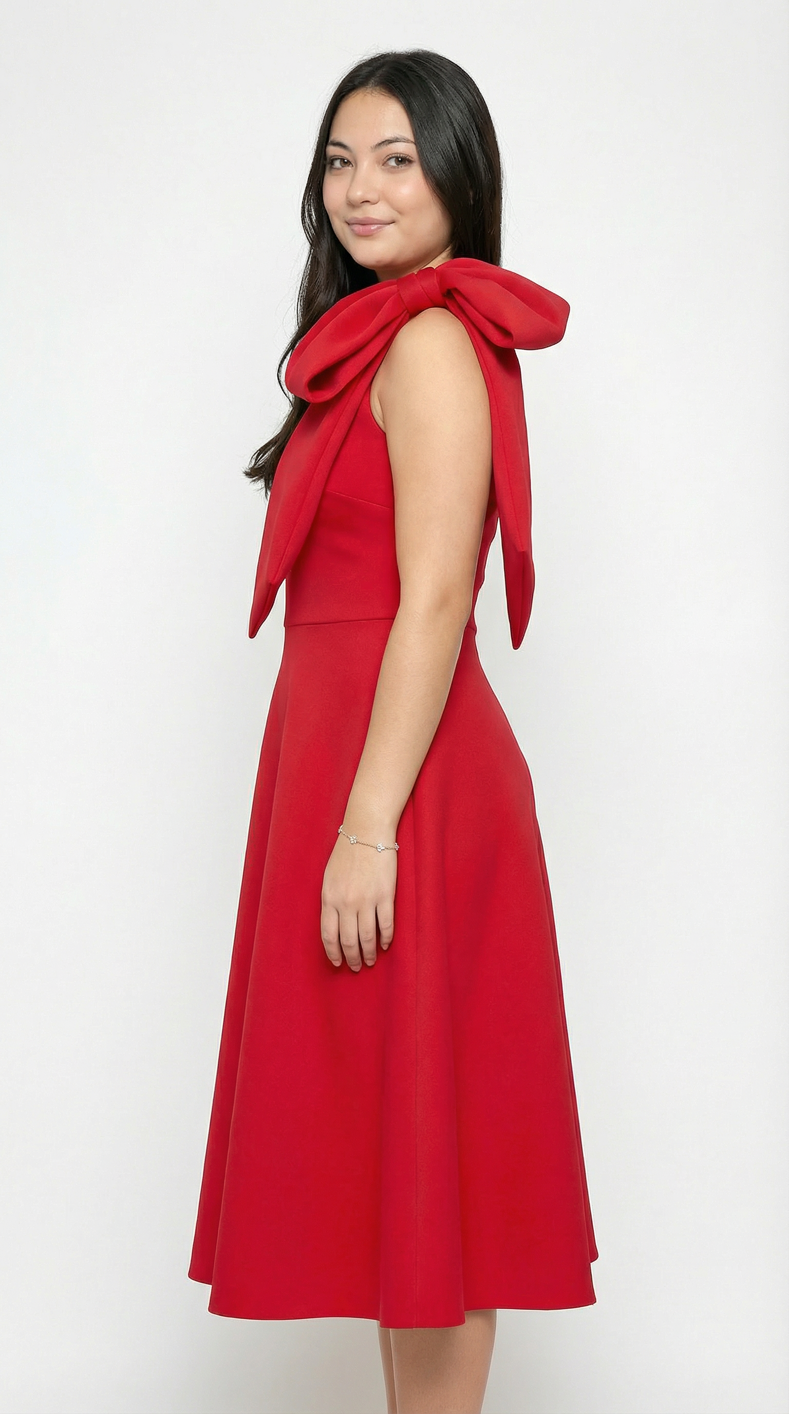 Woman wearing a red dress with a large bow on a white background