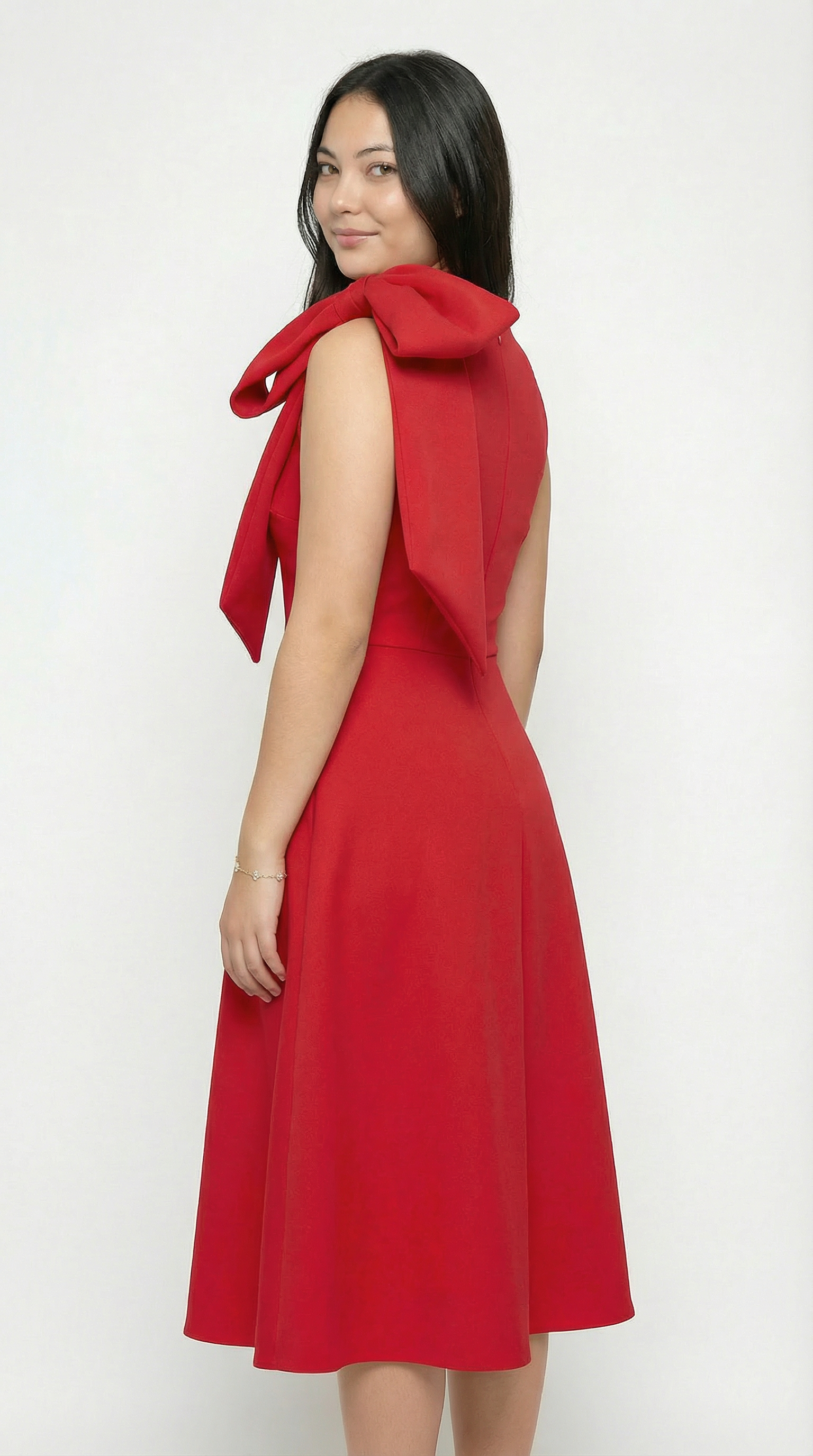 Woman wearing a red dress with a bow detail on a white background