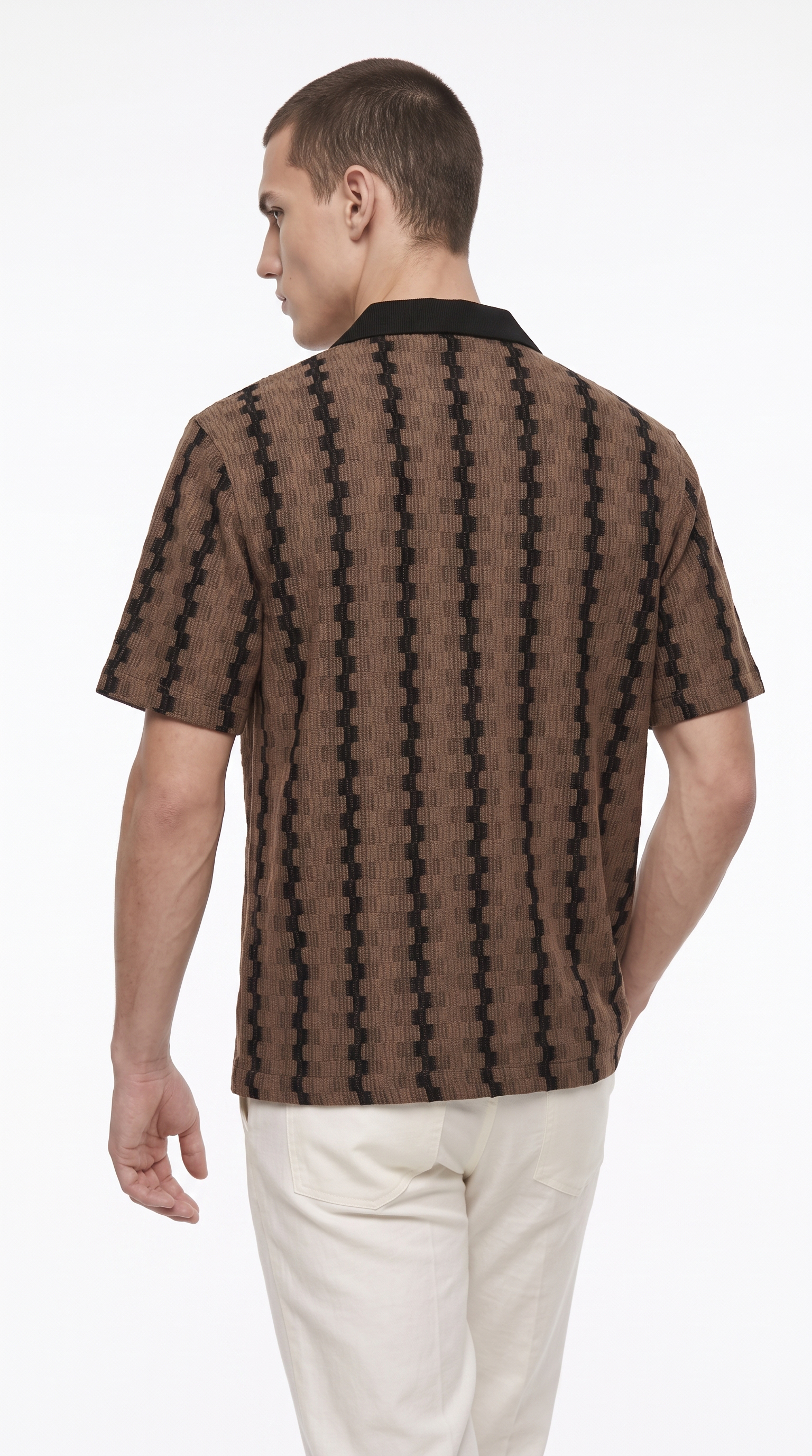 A man shown from the back wearing a brown short-sleeve button-up shirt with a black geometric pattern and a black collar, paired with off-white trousers, against a plain white studio background, from Meleche Fashion USA or Meléche (short as (Mé))