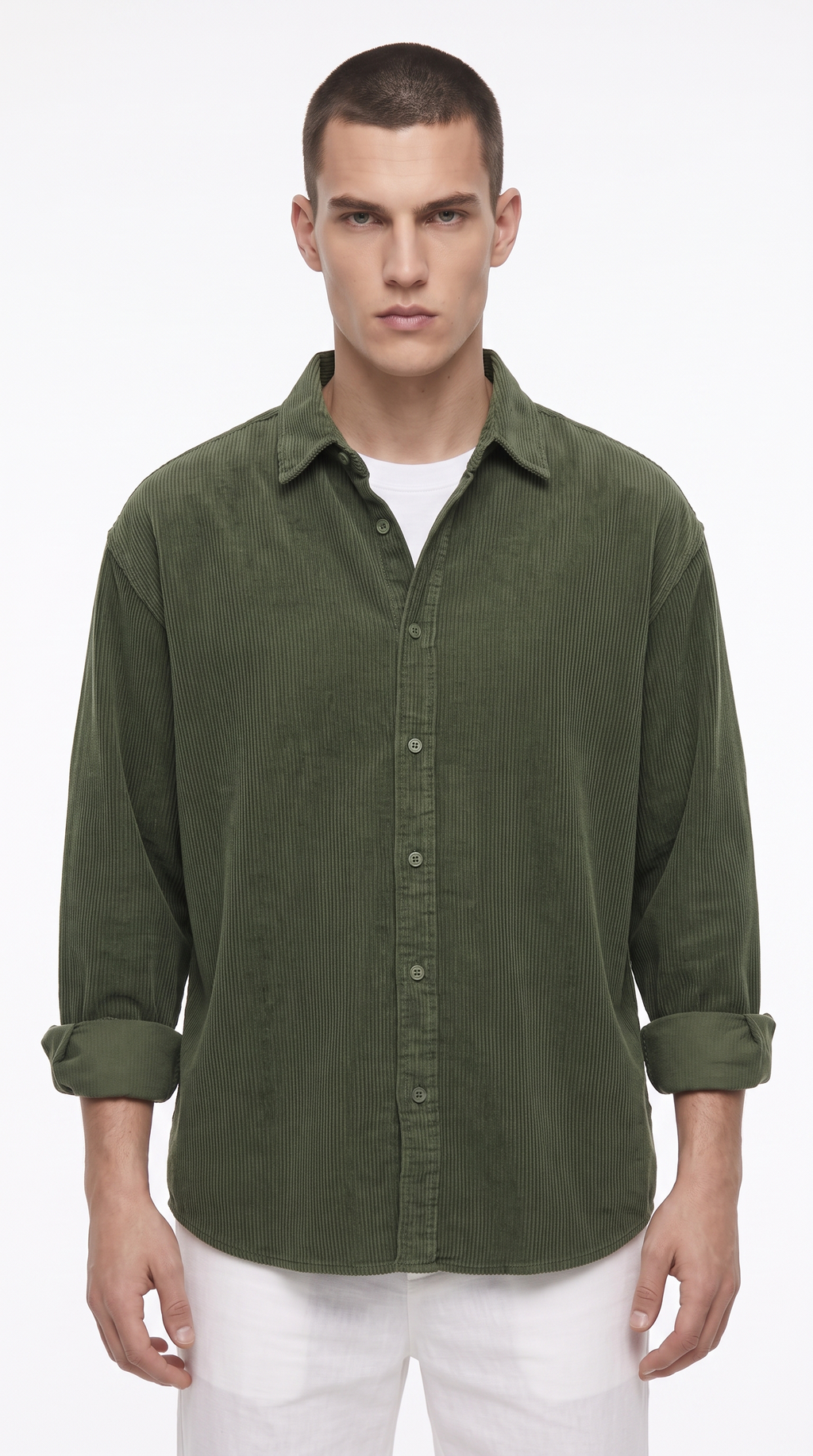 A man wearing an olive green long-sleeve button-up shirt with rolled-up cuffs, layered over a white t-shirt and paired with white pants, against a plain white studio background, from Meleche Fashion USA or Meléche (short as (Mé))