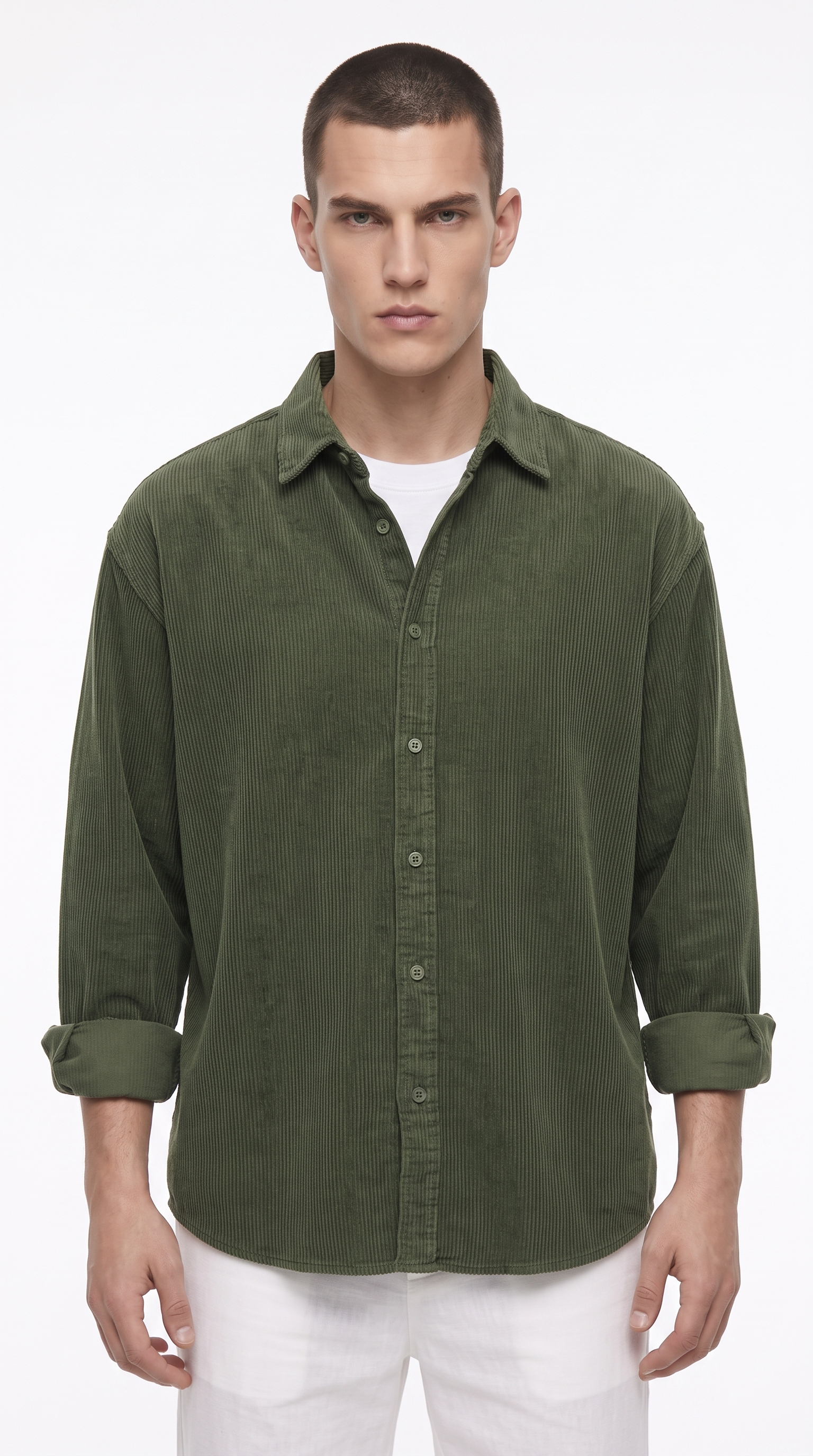 A man wearing an olive green long-sleeve button-up shirt with rolled-up cuffs, layered over a white t-shirt and paired with white pants, against a plain white studio background, from Meleche Fashion USA or Meléche (short as (Mé))