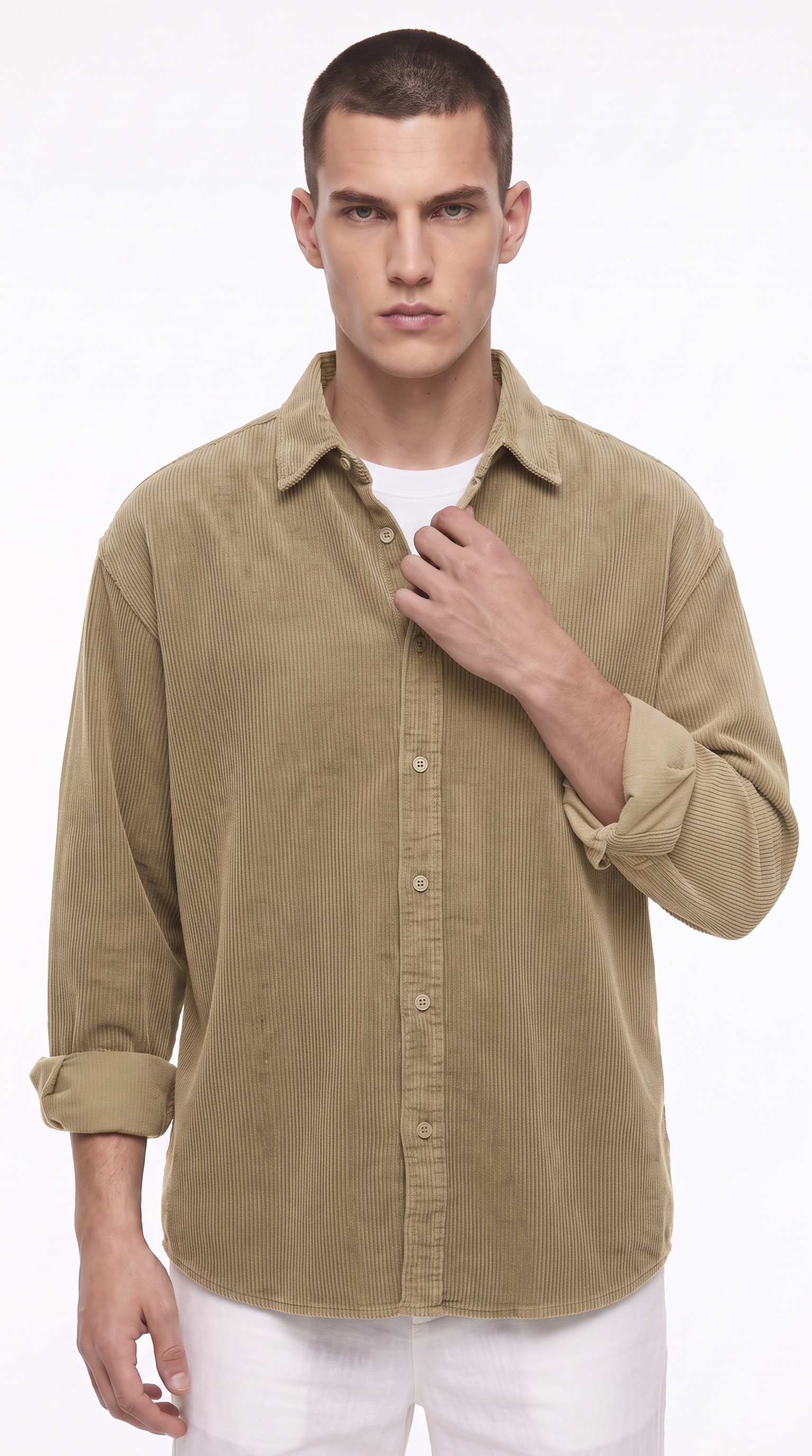 A man wearing a light brown corduroy button-down shirt over a white t-shirt and white pants, photographed against a plain white background, from Meleche Fashion USA or Meléche (short as (Mé))