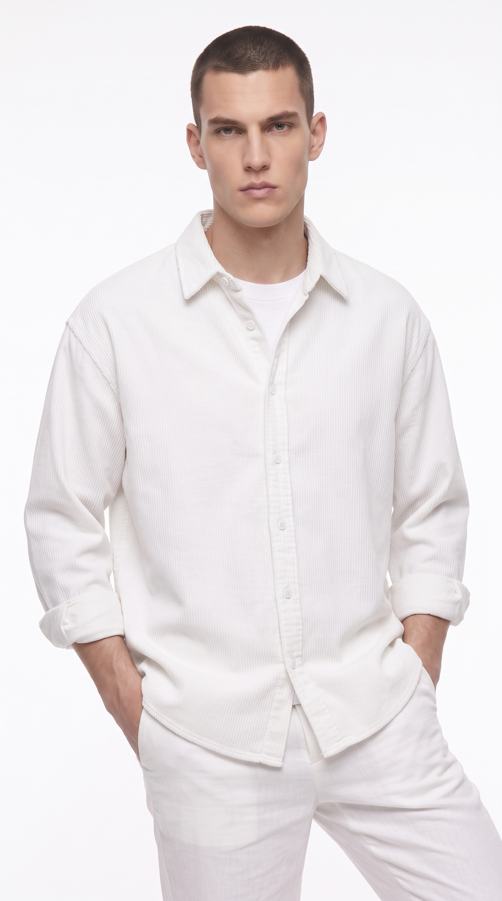 A male model wearing a white long-sleeve button-up shirt and matching white trousers, standing against a plain white studio background, from Meleche Fashion USA or Meléche (short as (Mé))