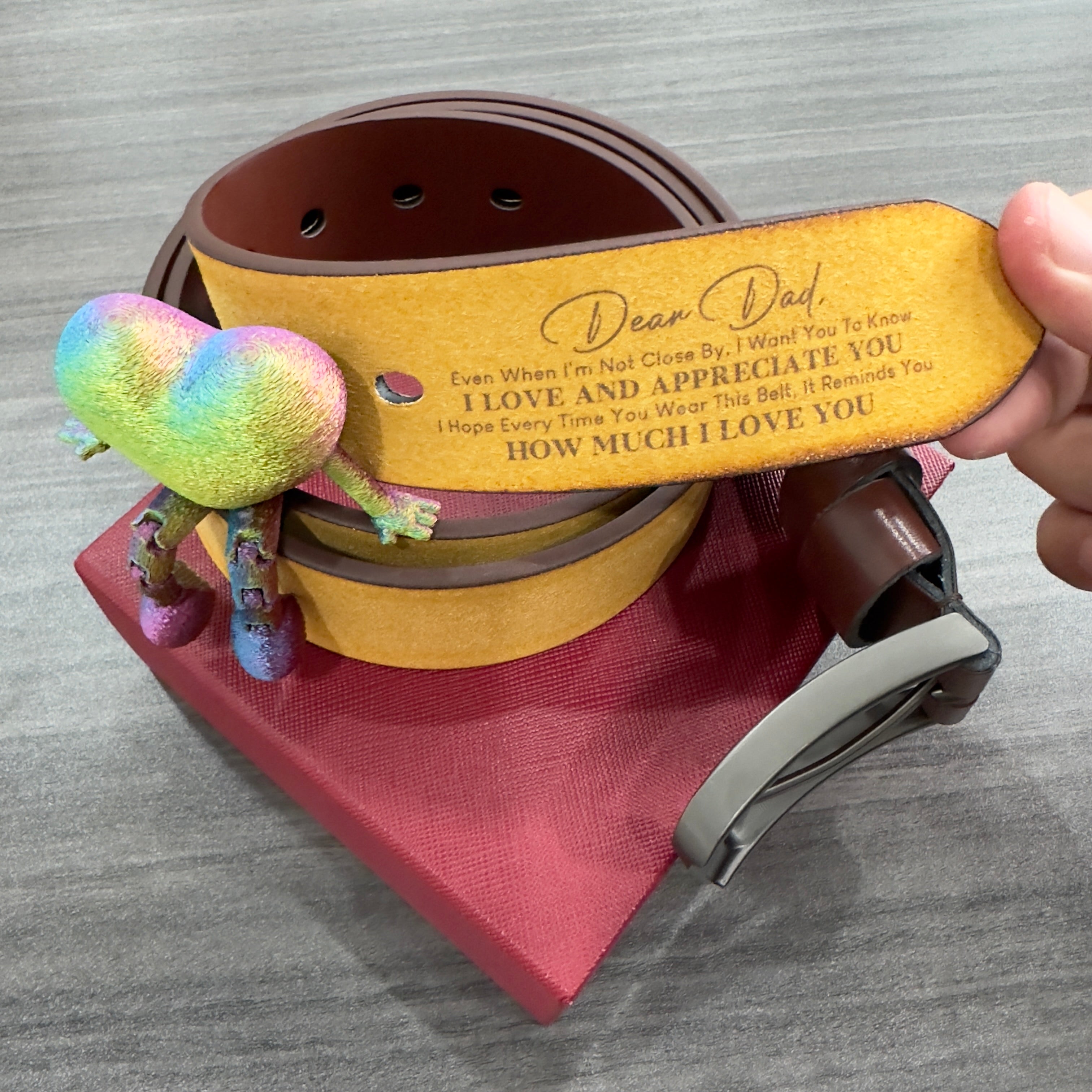 Gael belt Personalized leather belt with a message and a plush toy on a wooden surface from Meleche or Meléche (short as (Mé))