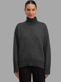 Woman wearing Gianna a dark gray turtleneck sweater from Meleche or Meléche (short as (Mé))