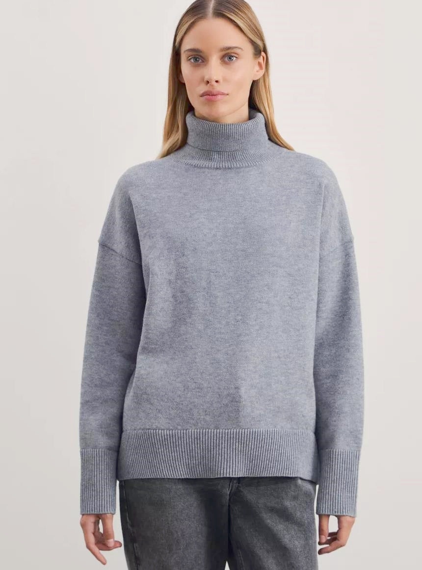 Person wearing a gray turtleneck sweater from Meleche or Meléche (short as (Mé))