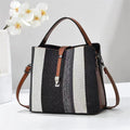 Goran Black and white striped handbag with brown accents on a light gray background