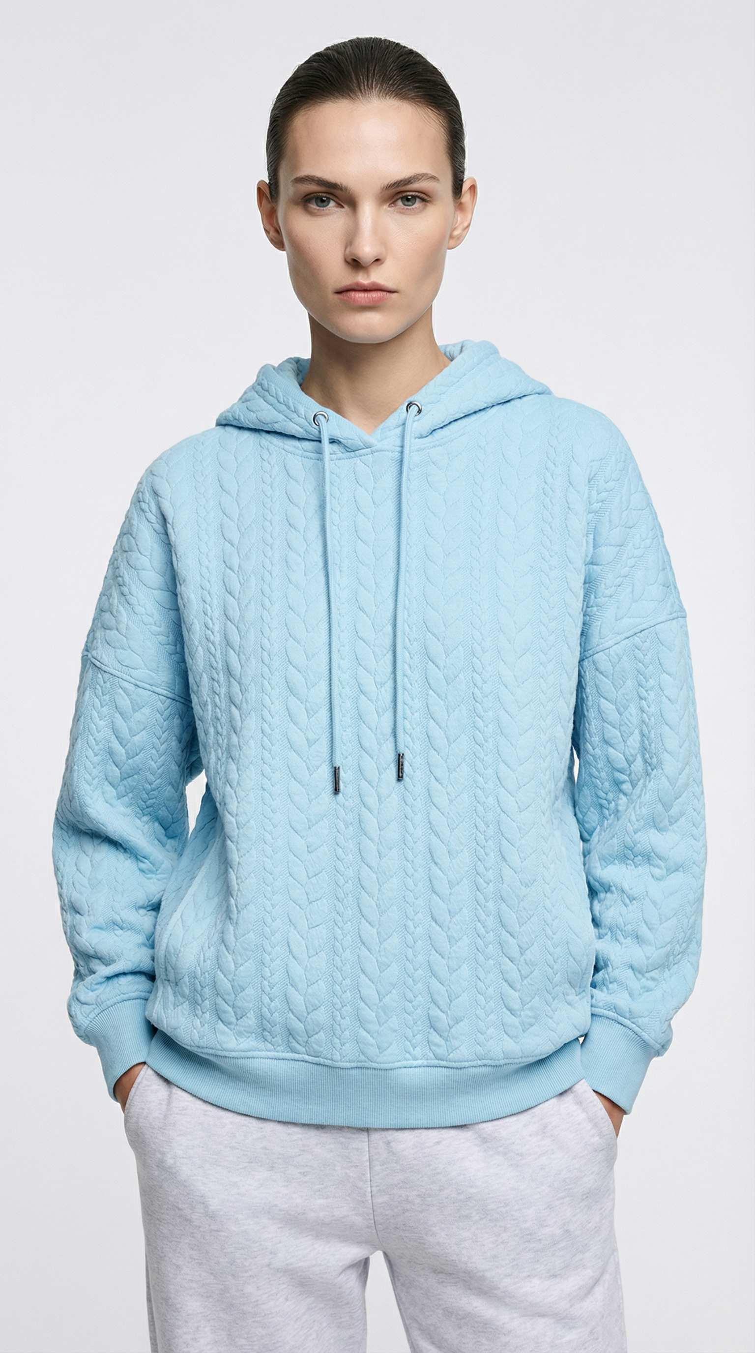 Jenna Ortega wearing a light blue cable knit hoodie on a white pants from Meleche or Meléche (short as (Mé))