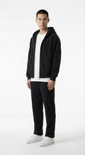 Person wearing a black jacket, white shirt, and pants standing against a gray wall with a flame graphic and text.