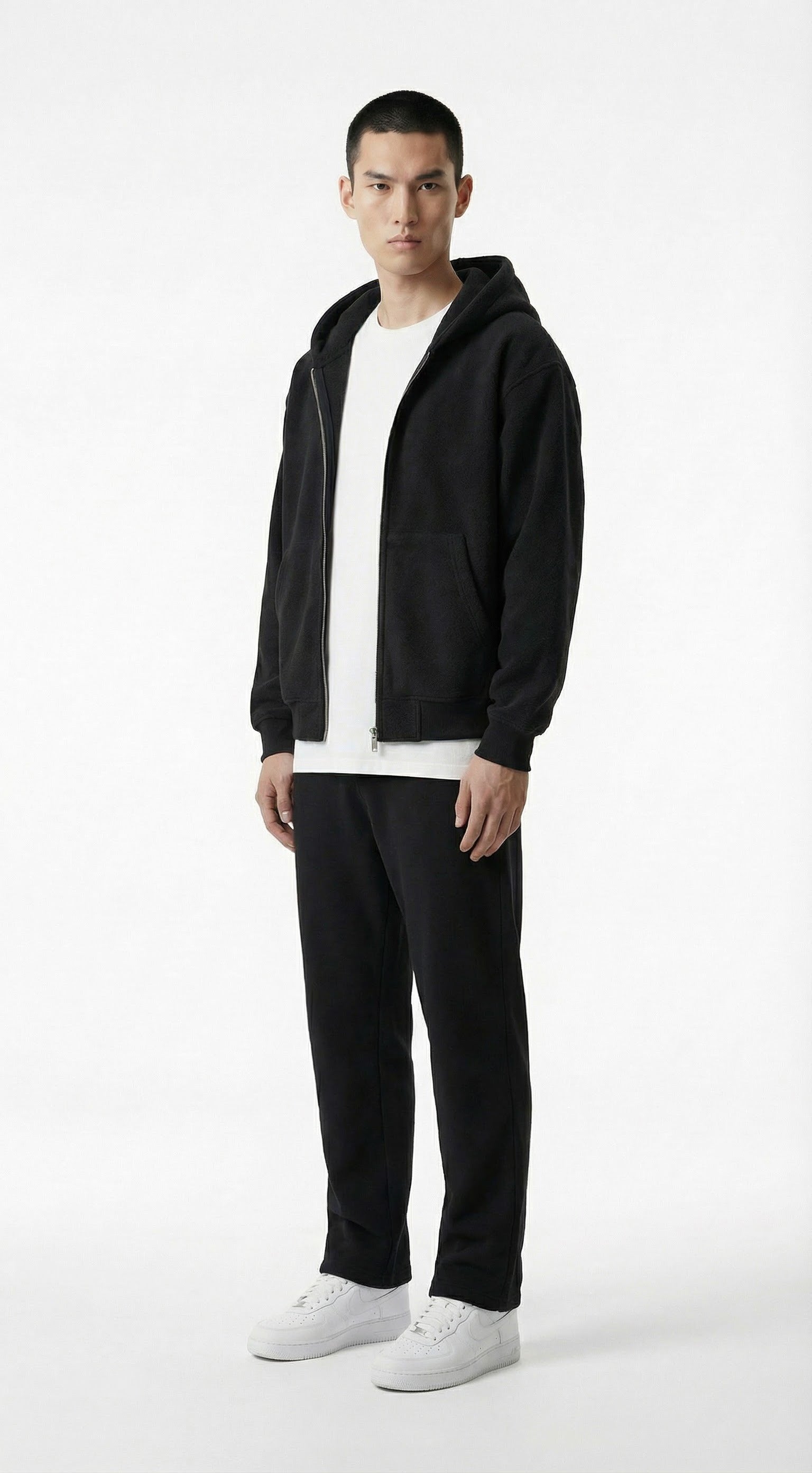 Person wearing a black jacket, white shirt, and pants standing against a gray wall with a flame graphic and text.