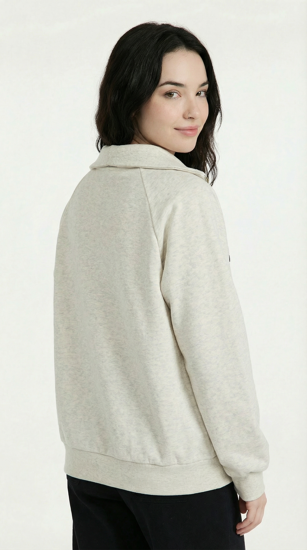 Woman wearing a beige sweater against a white background