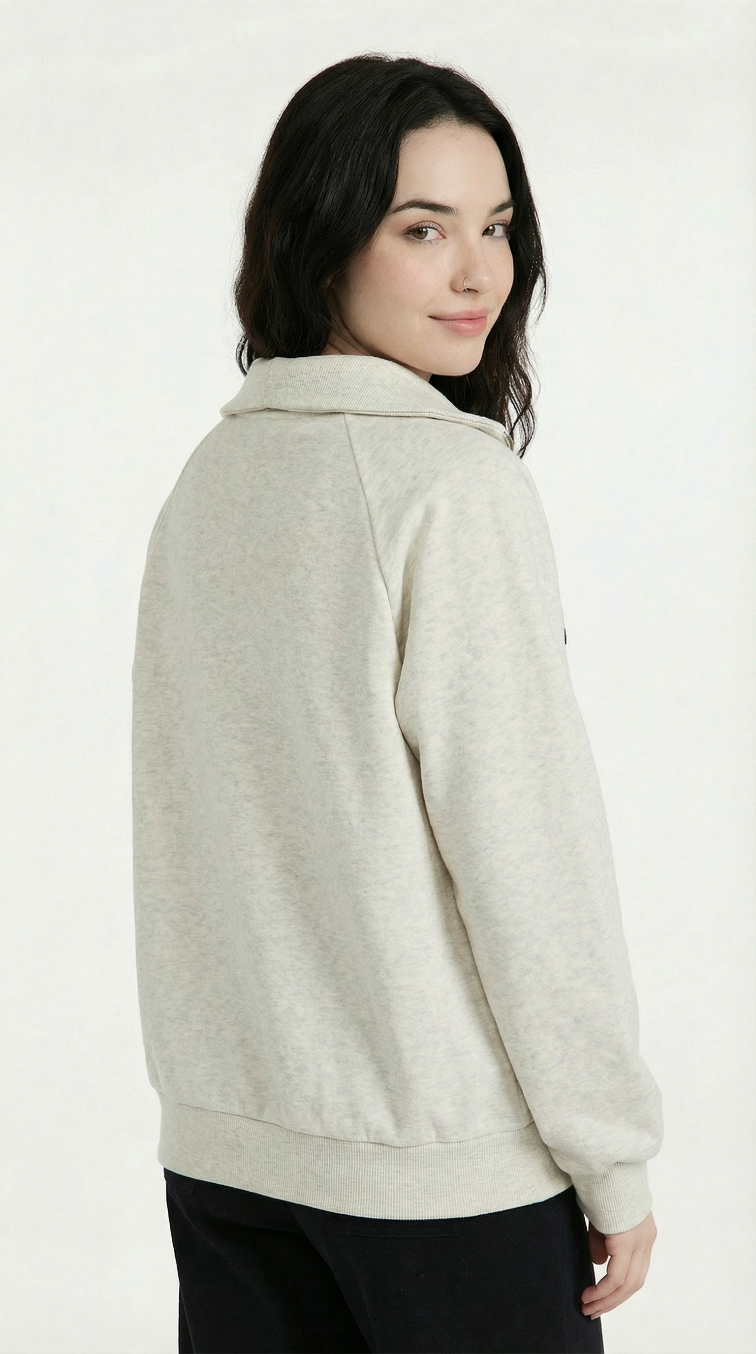 Woman wearing a beige sweater against a white background