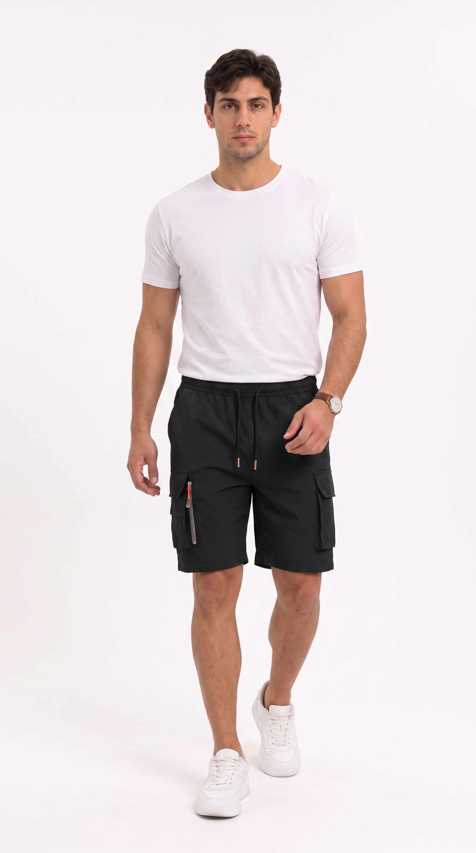 A man modeling black cargo shorts with white sneakers and a white t-shirt, standing against a plain white studio background, from Meleche Fashion USA or Meléche (short as (Mé))