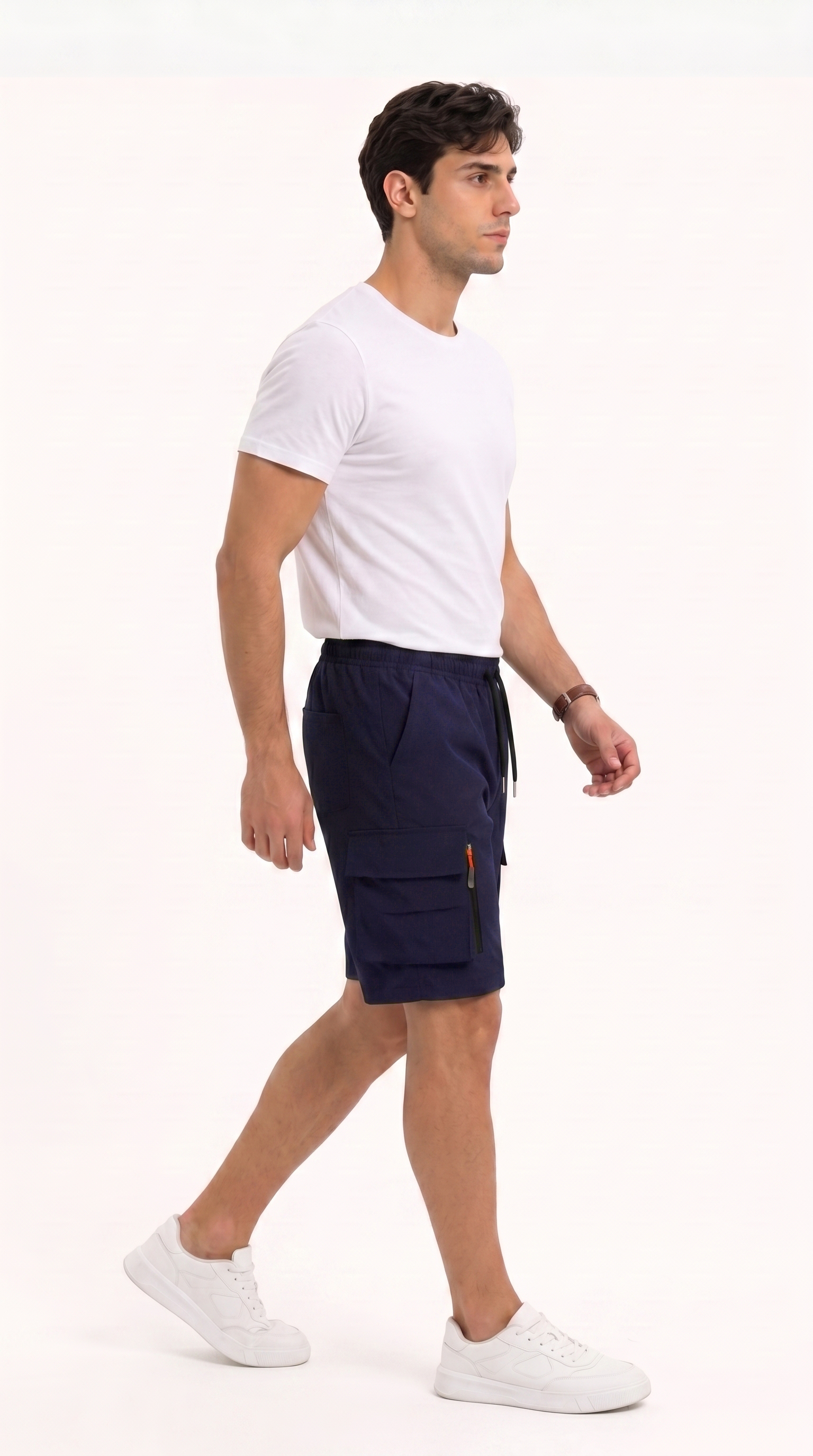 A man in a white t-shirt and navy blue cargo shorts walking in profile against a plain white studio background, from Meleche Fashion USA or Meléche (short as (Mé))
