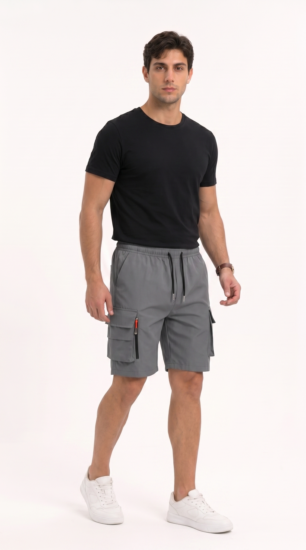 A man modeling gray cargo shorts with a black t-shirt and white sneakers against a plain white studio background, from Meleche Fashion USA or Meléche (short as (Mé))